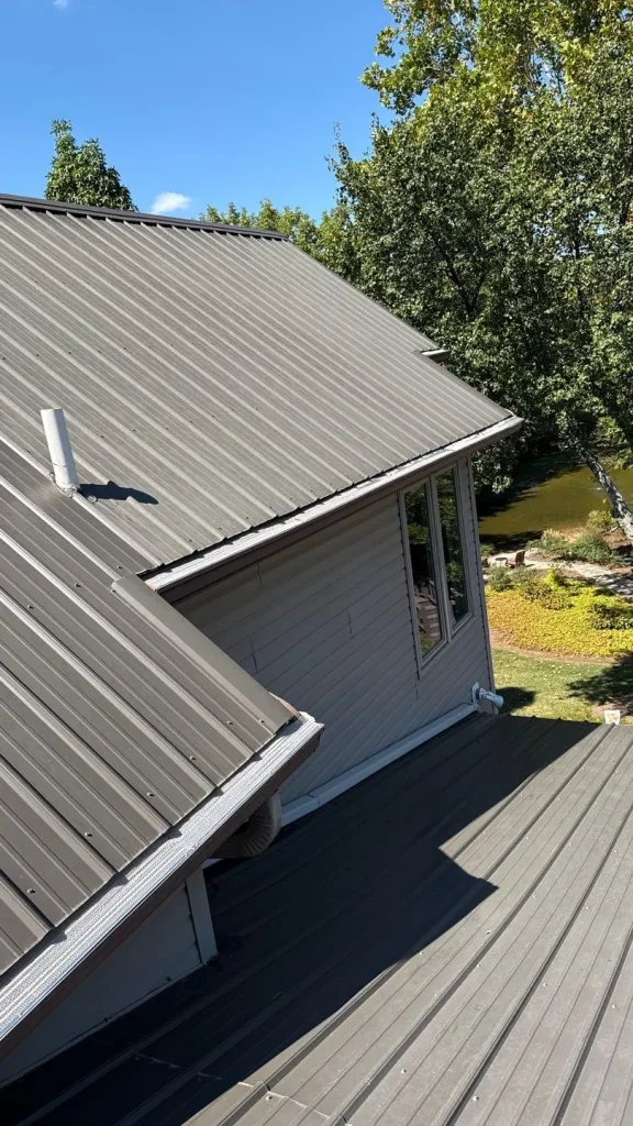 Gutter guards installed on a Louisville home with a gray metal roof, keeping leaves out and ensuring proper water drainage.