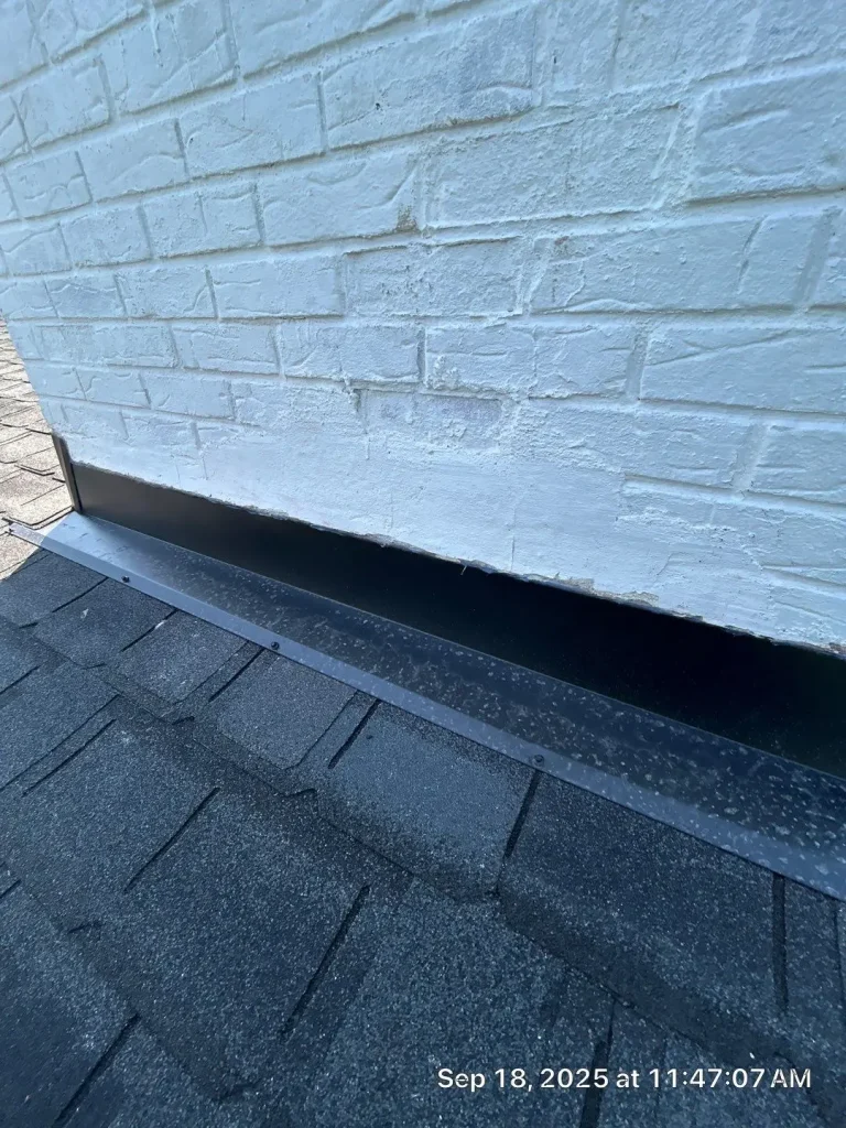Louisville roof with white brick chimney and new black flashing installed at the base for leak protection.