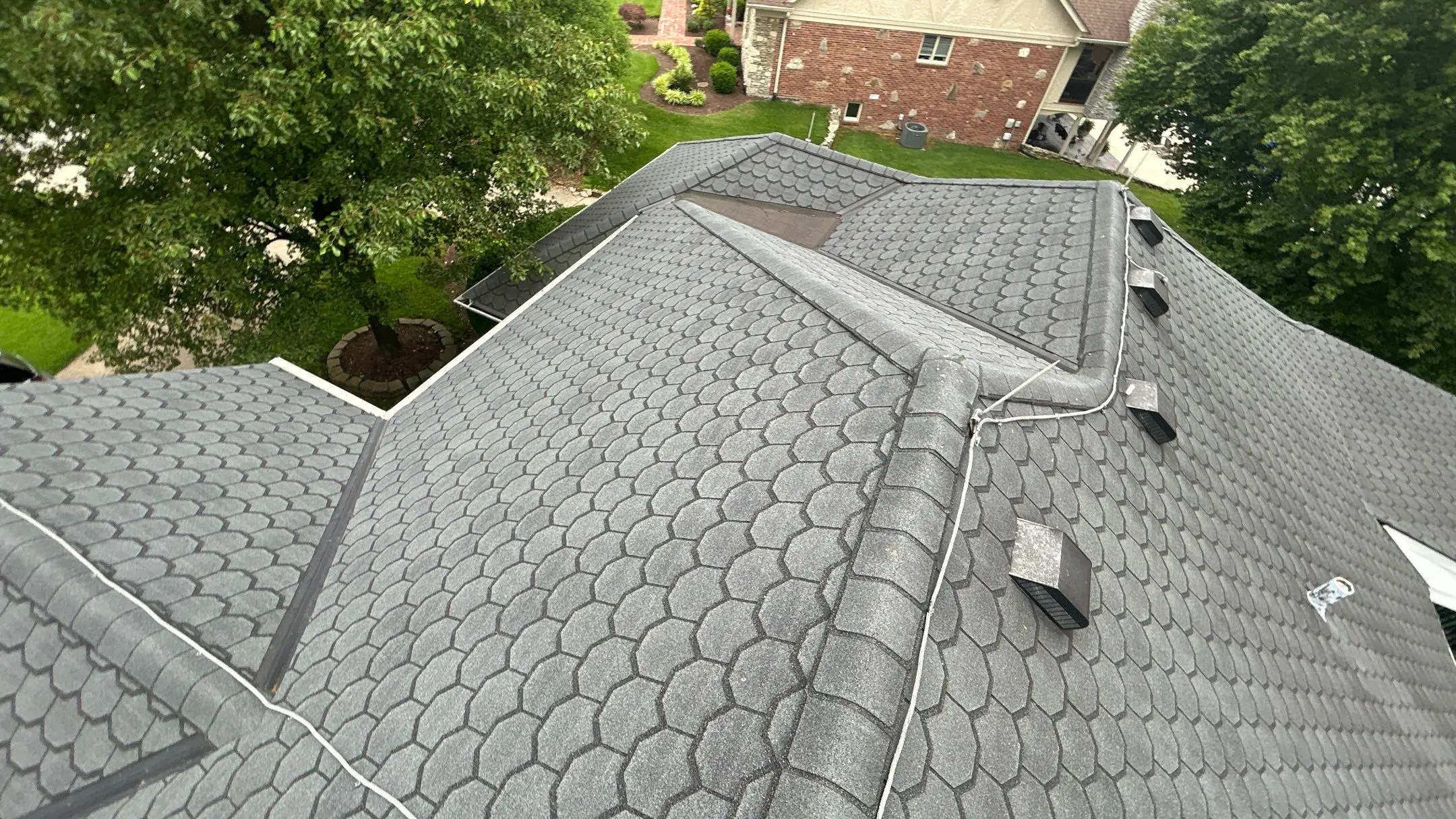 Louisville home roof with gray patterned shingles, ridge line detail, and multiple ventilation penetrations.