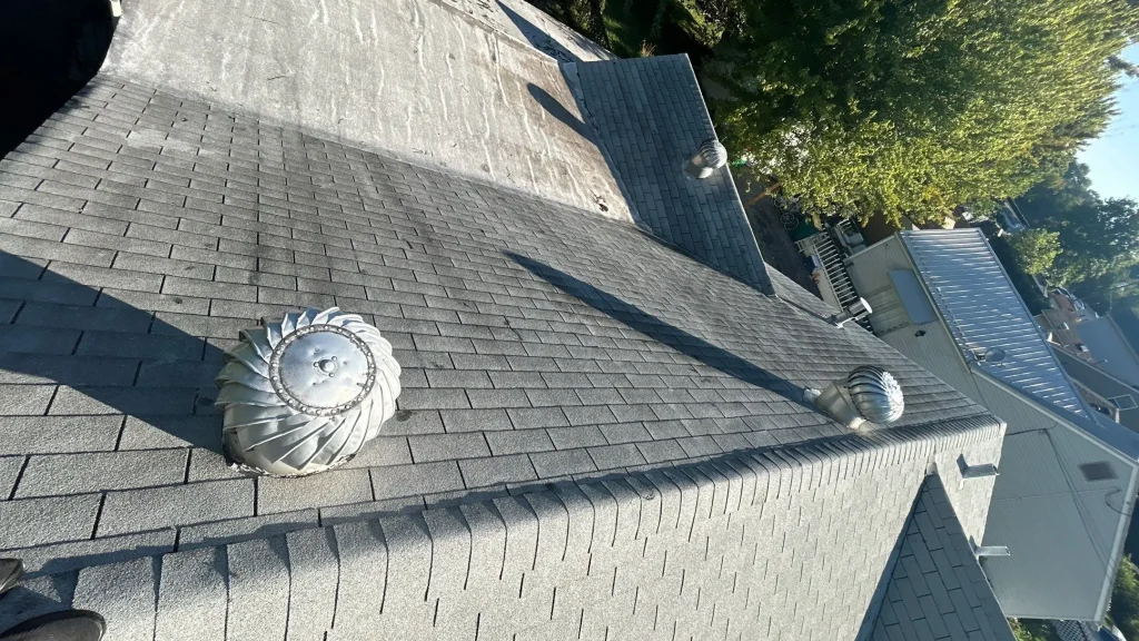 Louisville roof ridge with light gray asphalt shingles and multiple turbine vents for ventilation.