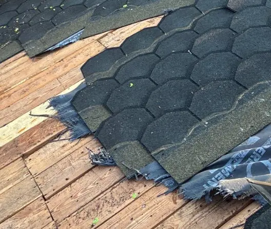 Louisville roof with missing shingles and exposed decking needing urgent repair.