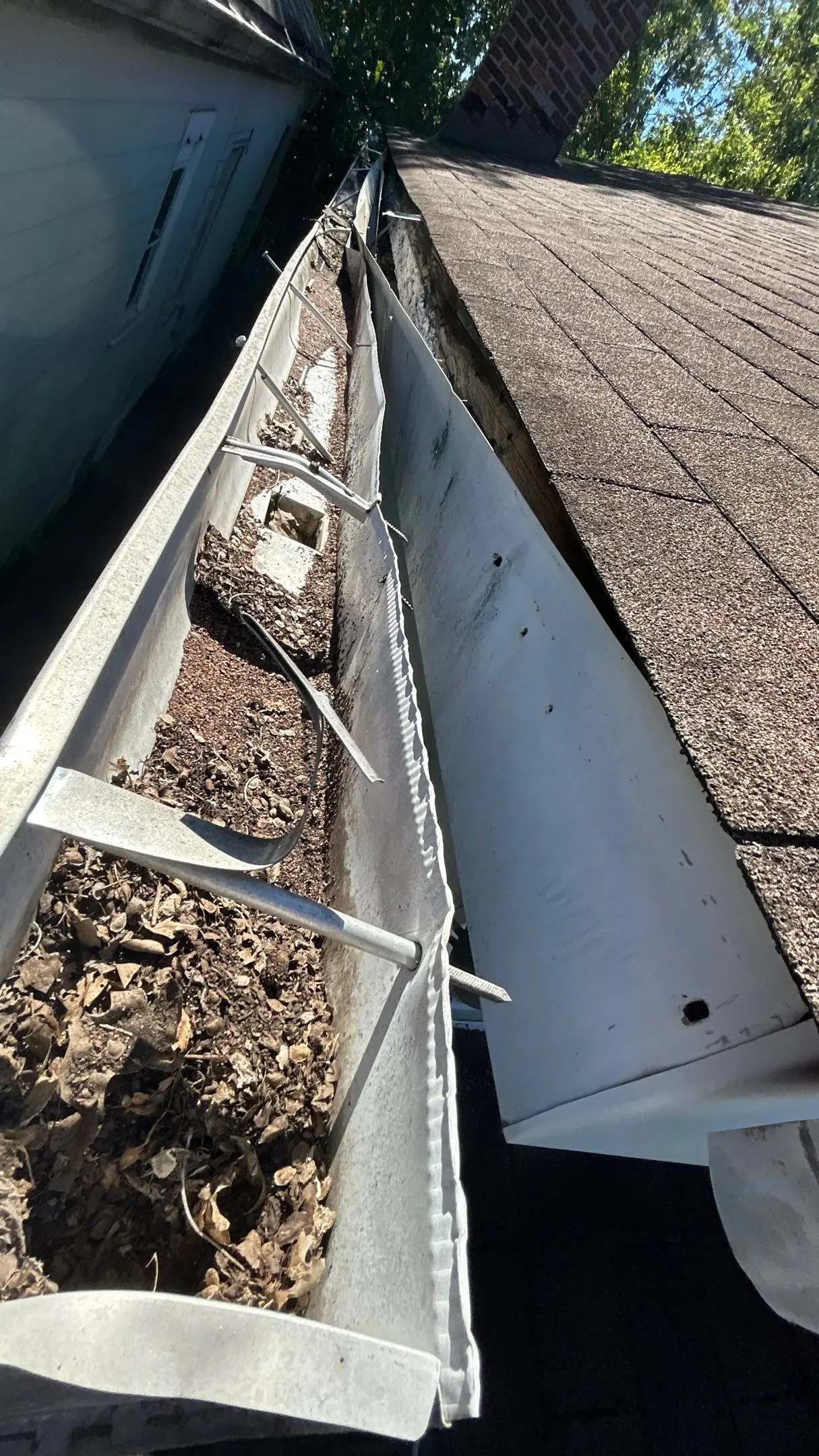 Old Gutter with Water Damage on Louisville Home Clogged and damaged gutter filled with debris before repair on a home in Bardstown, Kentucky.