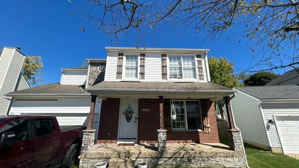 Two-story home in Bardstown, KY after a full roof replacement with asphalt shingles under a clear blue sky.