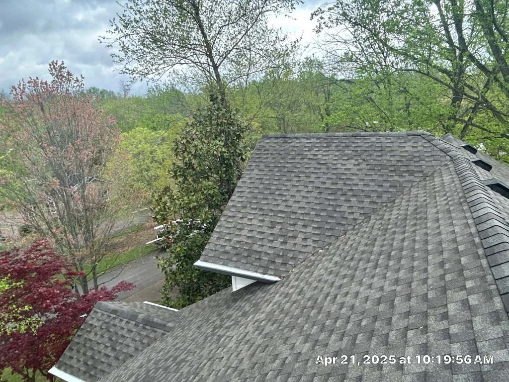 New gutter guards installed along a high roofline on a Shelbyville, Kentucky home surrounded by trees.
