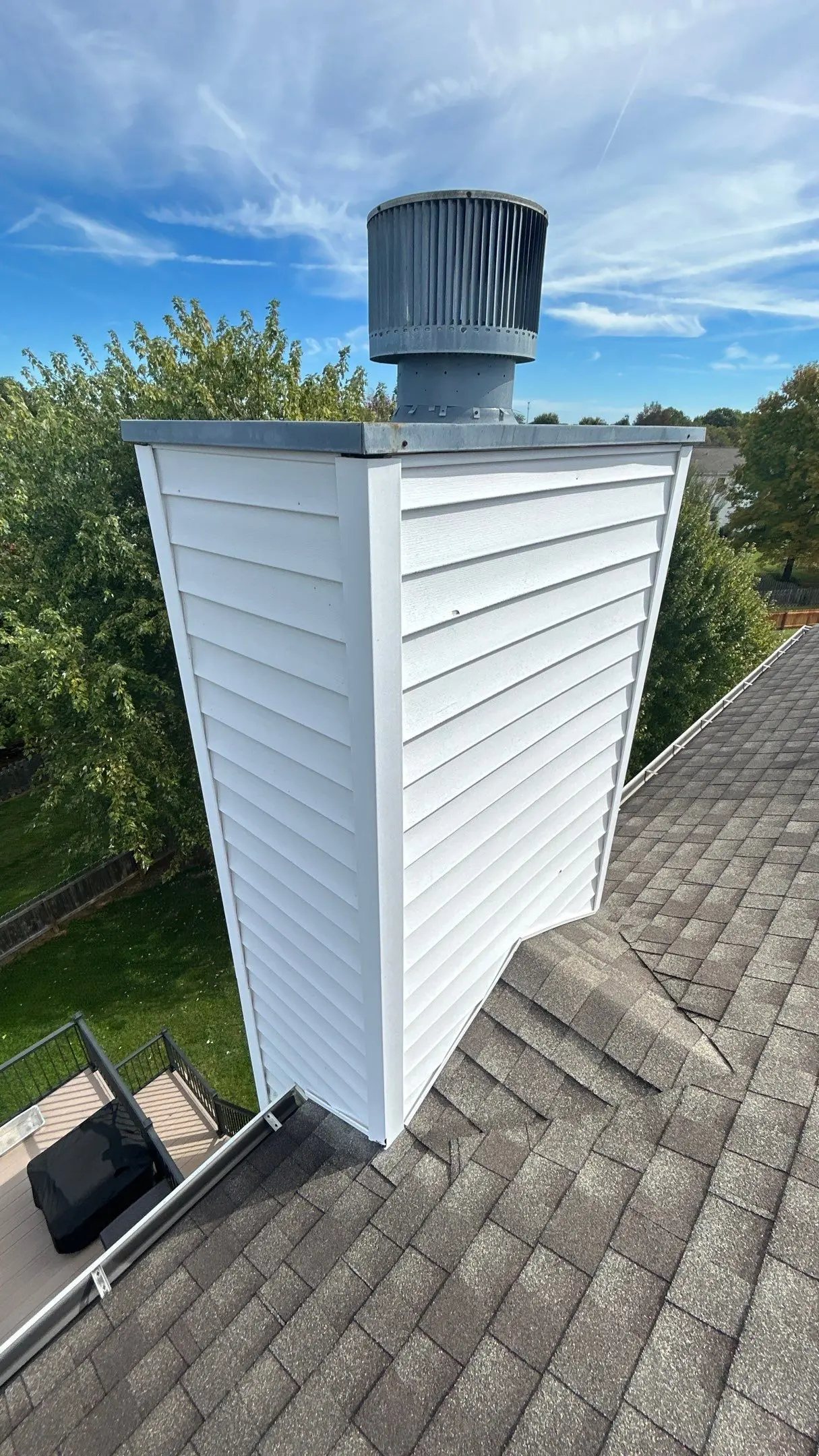 Chimney Flashing Inspection on Louisville Roof Newly finished chimney chase with white vinyl siding and fresh flashing on a Louisville home’s shingle roof.