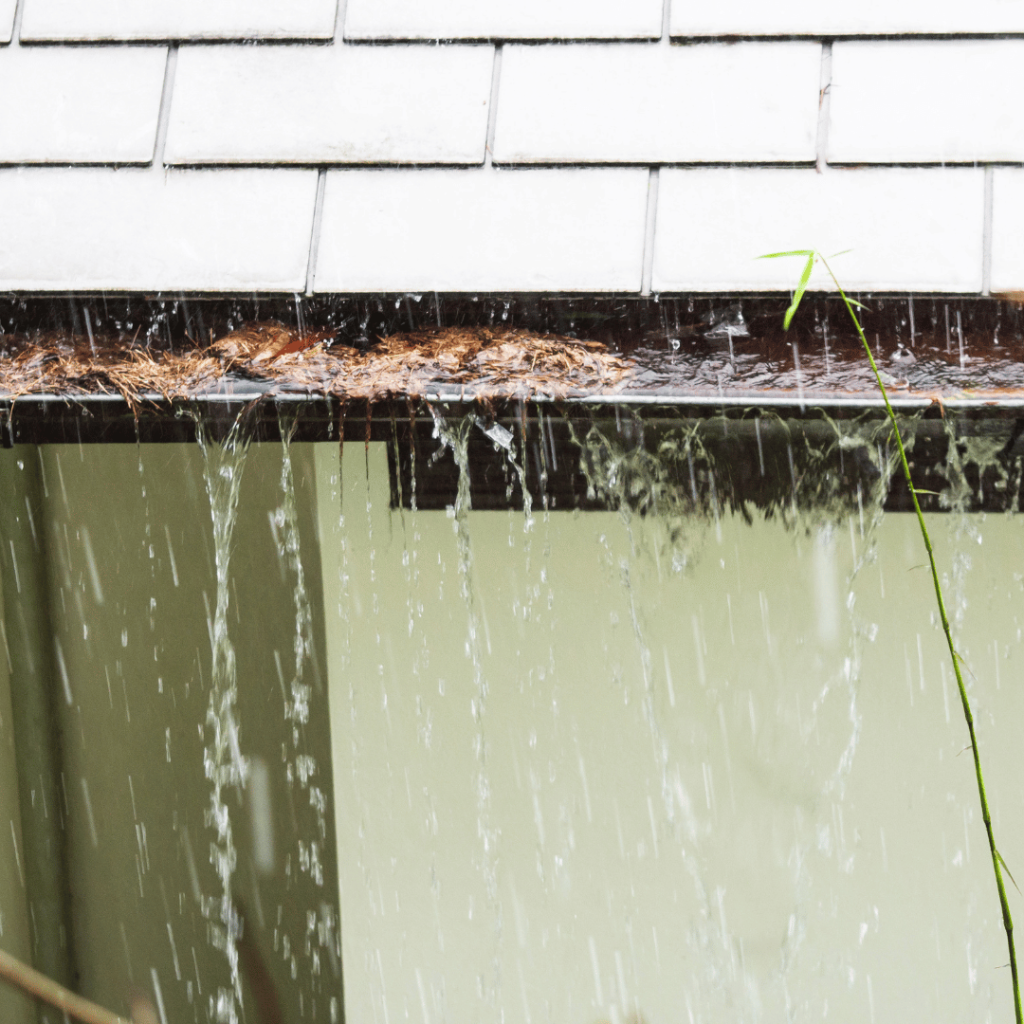Clogged gutter overflowing during rain on a Shelbyville, Kentucky home, showing water spilling over the edge.