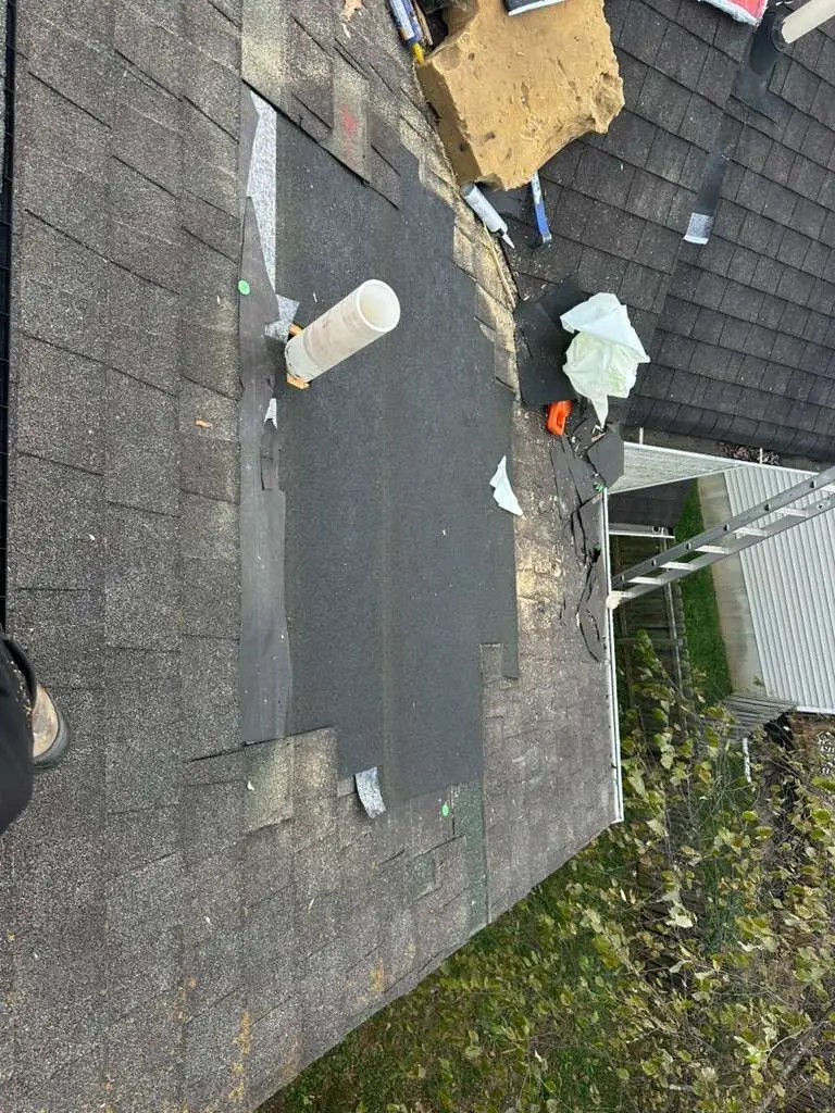 Roof repair in progress on a Louisville home showing missing shingles, exposed underlayment, and roof vent pipe installation.