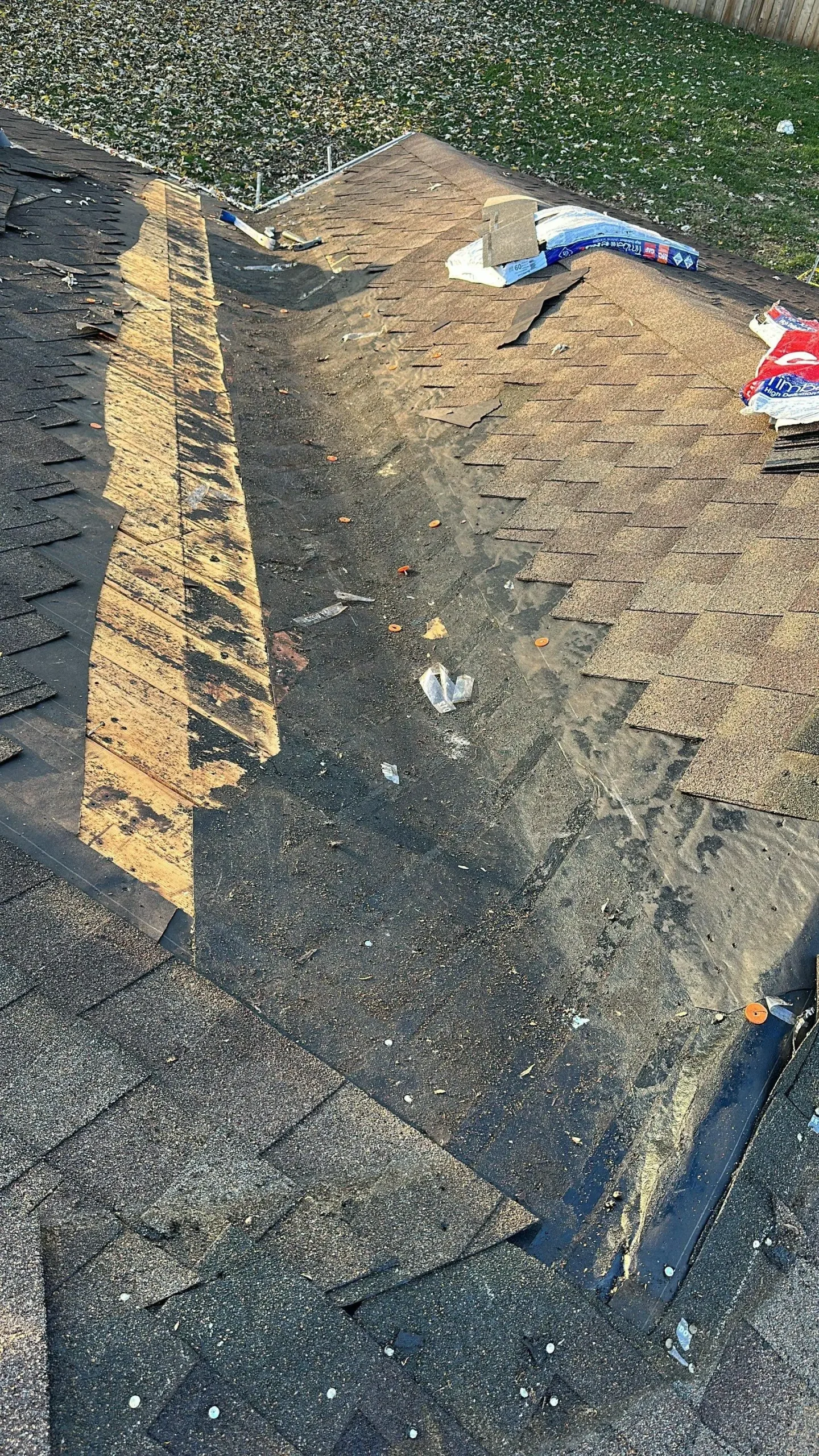 Roof valley with torn shingles, exposed underlayment, and debris visible during a roof repair on a Louisville KY home.