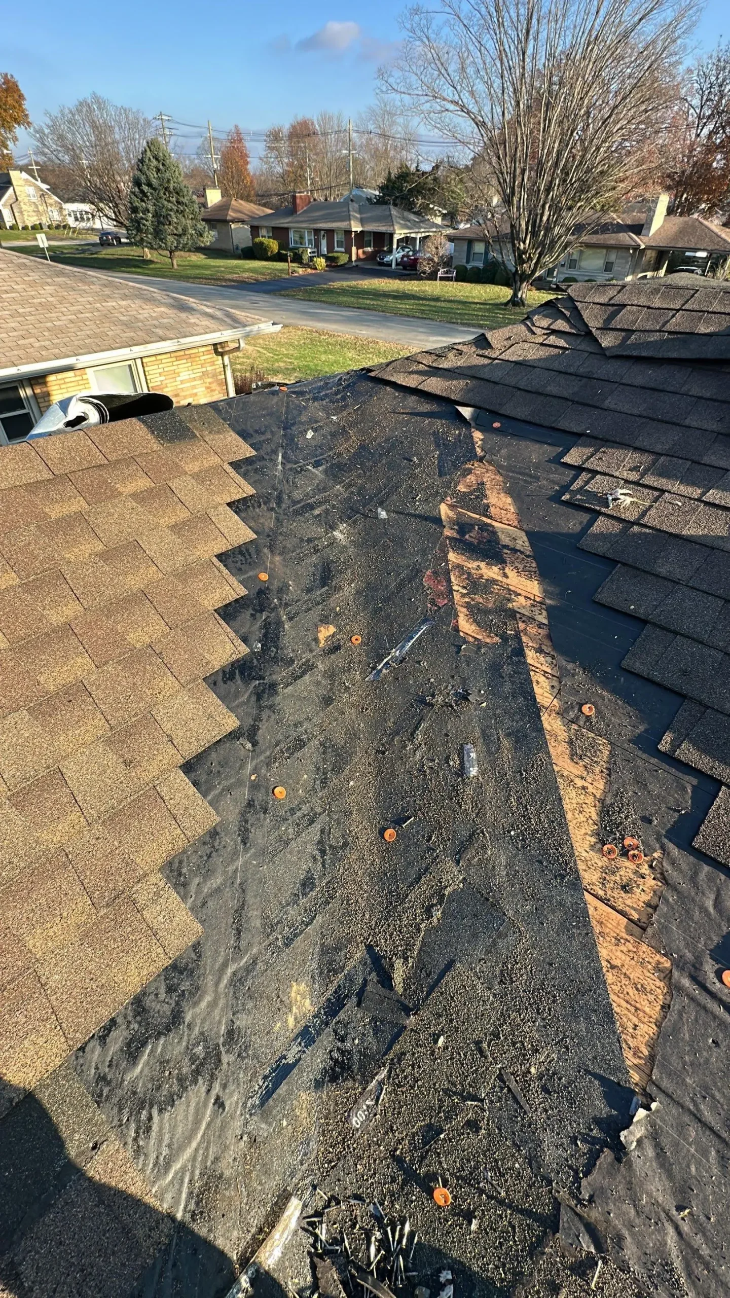 Missing shingles and exposed underlayment on a Louisville KY roof showing a damaged valley.
