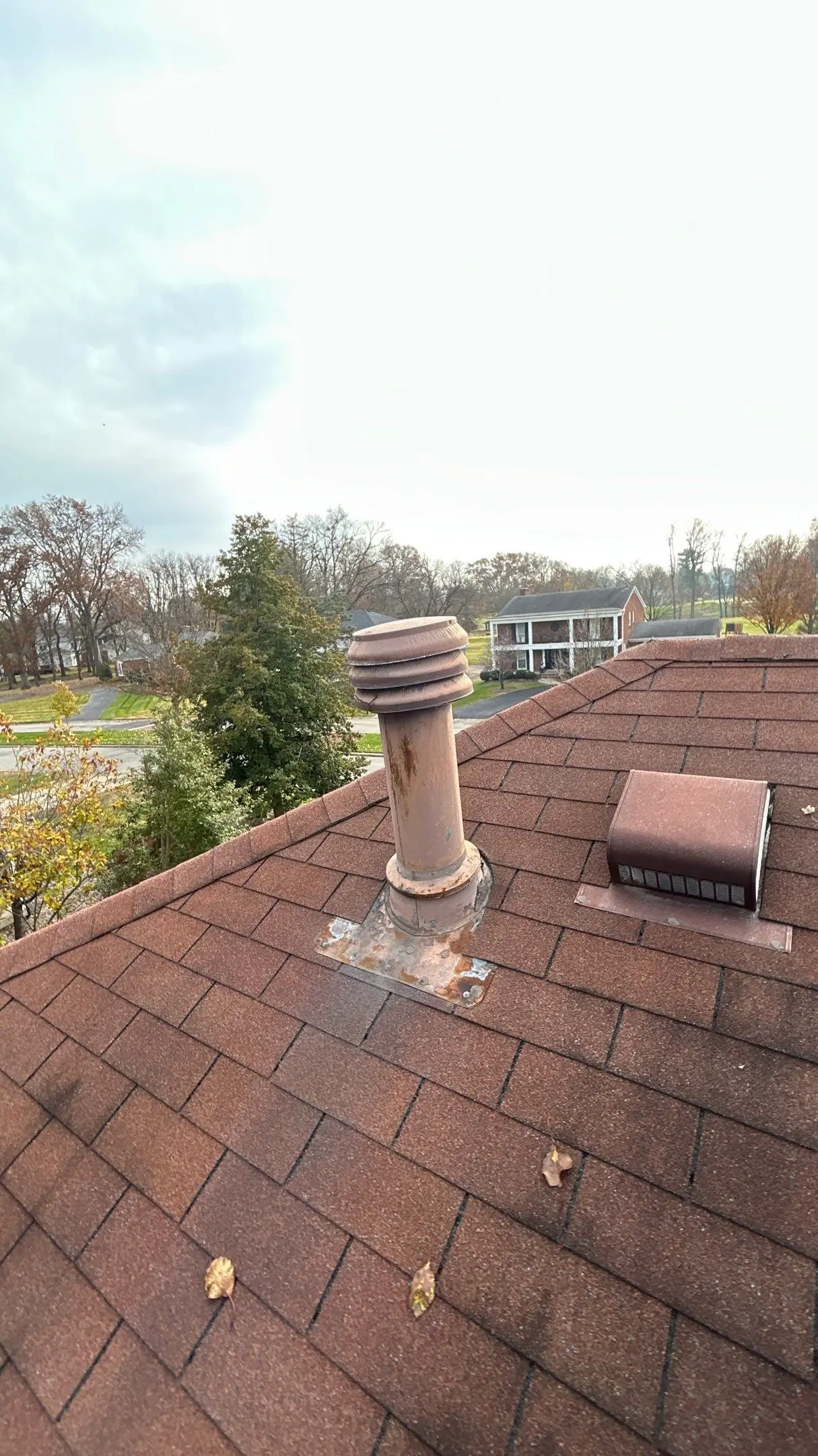 Rusted roof penetration with deteriorating flashing on a Louisville, KY shingle roof needing repair.