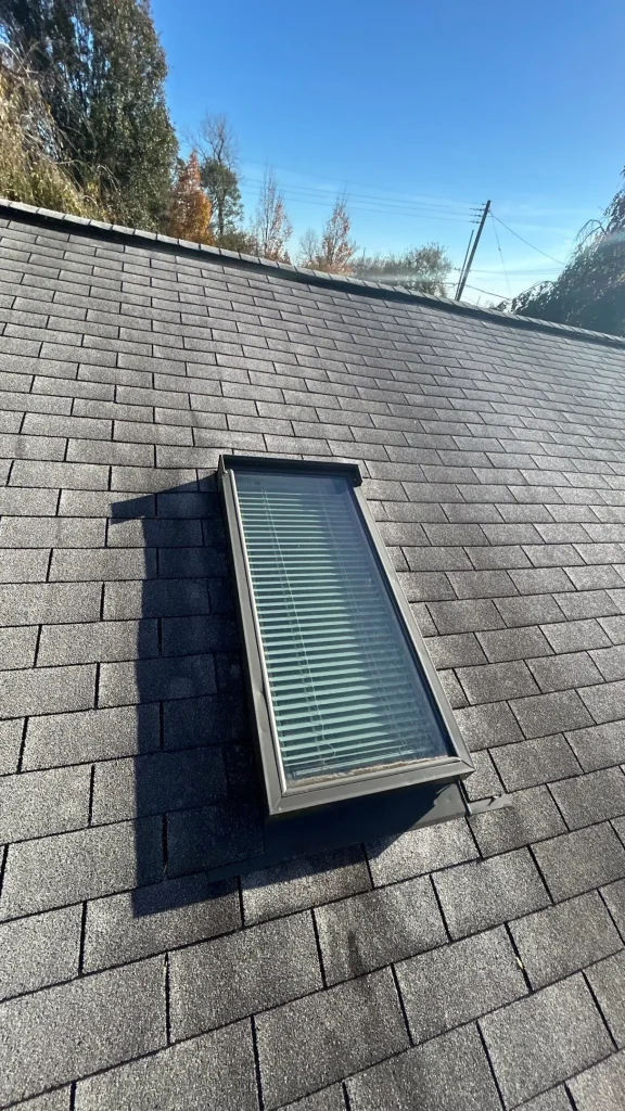 Skylight on an asphalt shingle roof in Louisville, KY with signs of wear around the flashing during a roof inspection.