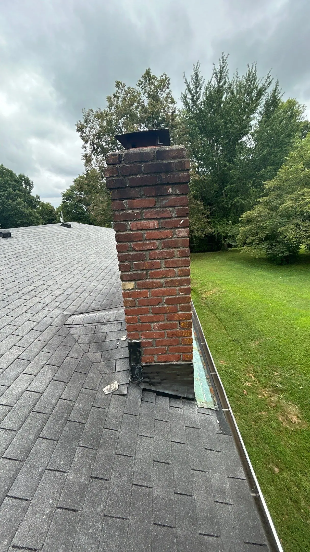 Chimney flashing damage on a residential roof in Louisville, Kentucky exposing vulnerable areas to leaks
