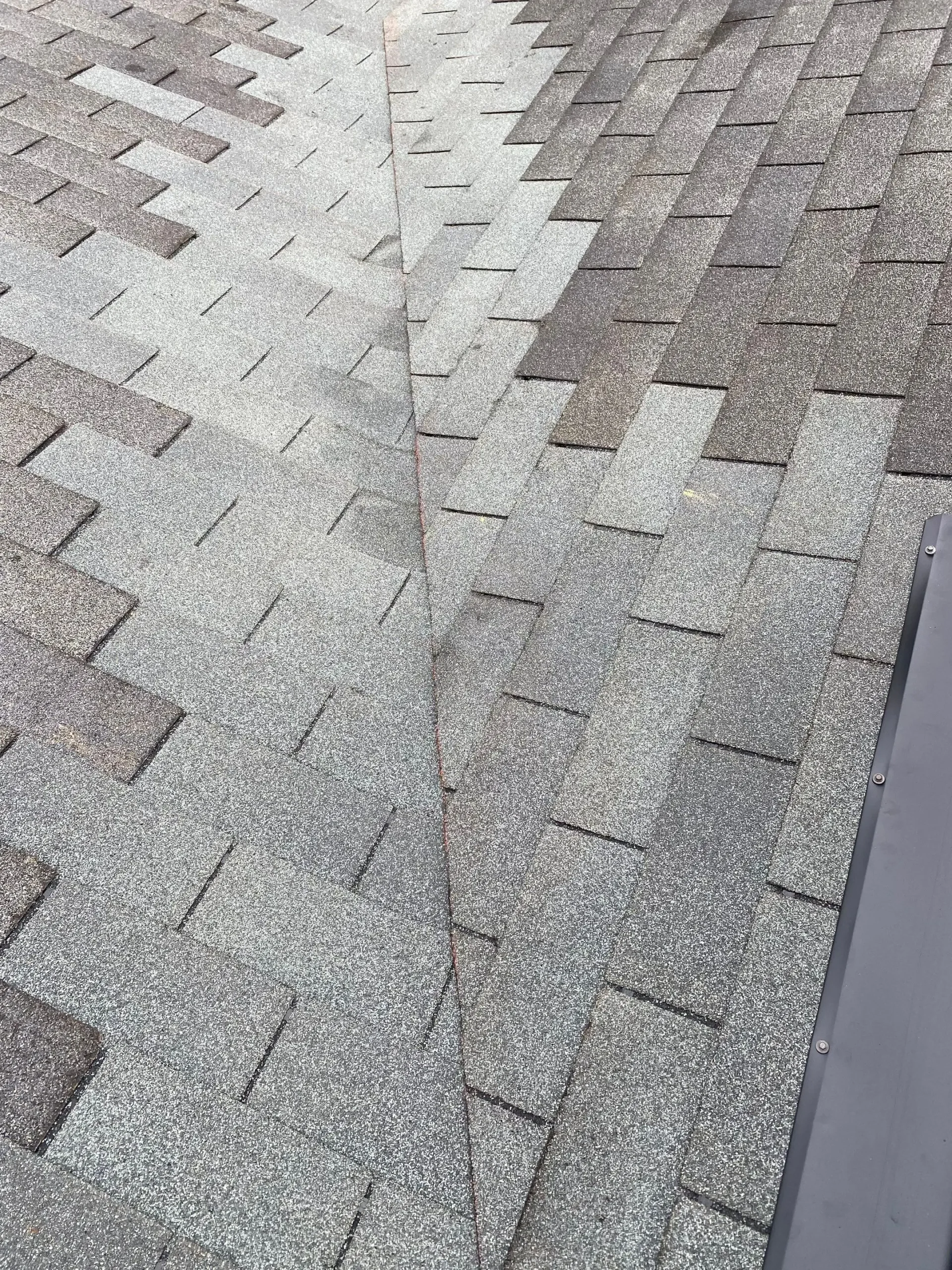 Discolored asphalt shingles on a residential roof in Pewee Valley, Kentucky, showing uneven wear and aging shingles