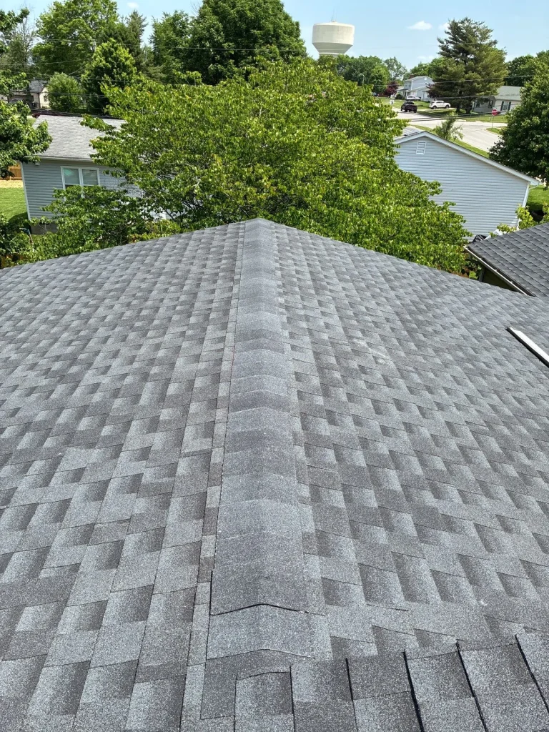 Finished asphalt shingle roof with straight ridge line and uniform shingle pattern