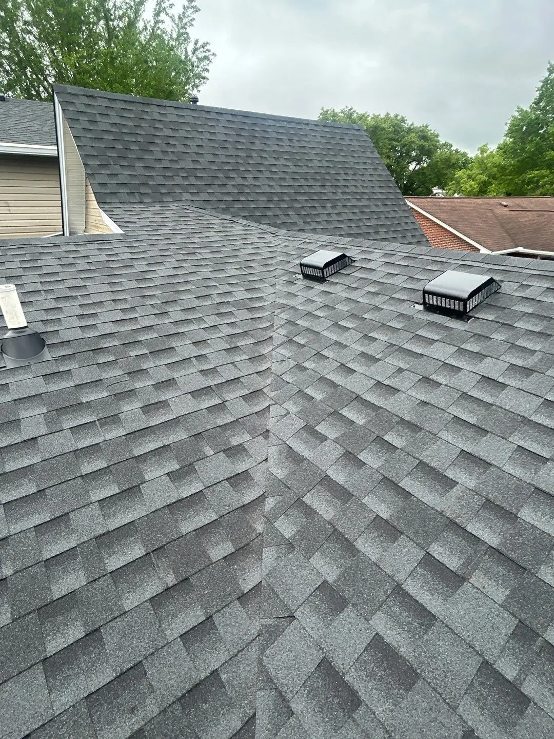 Finished asphalt shingle roof with uniform shingle pattern and proper roof transitions
