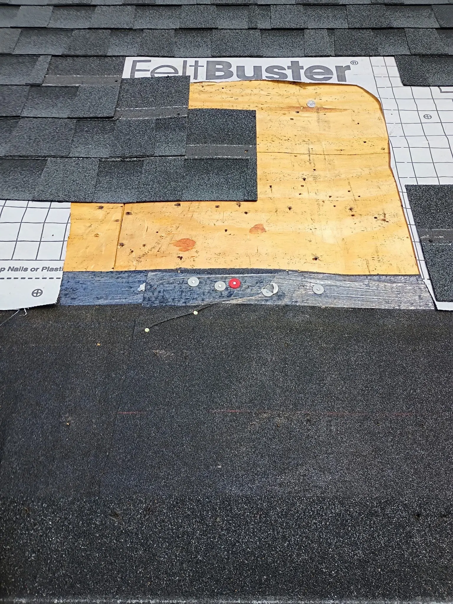 Roof repair showing exposed FeltBuster underlayment during shingle replacement