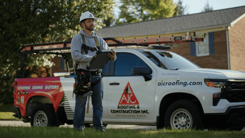 Roofing contractor standing in front of company truck preparing for a free roof inspection and free siding inspection.