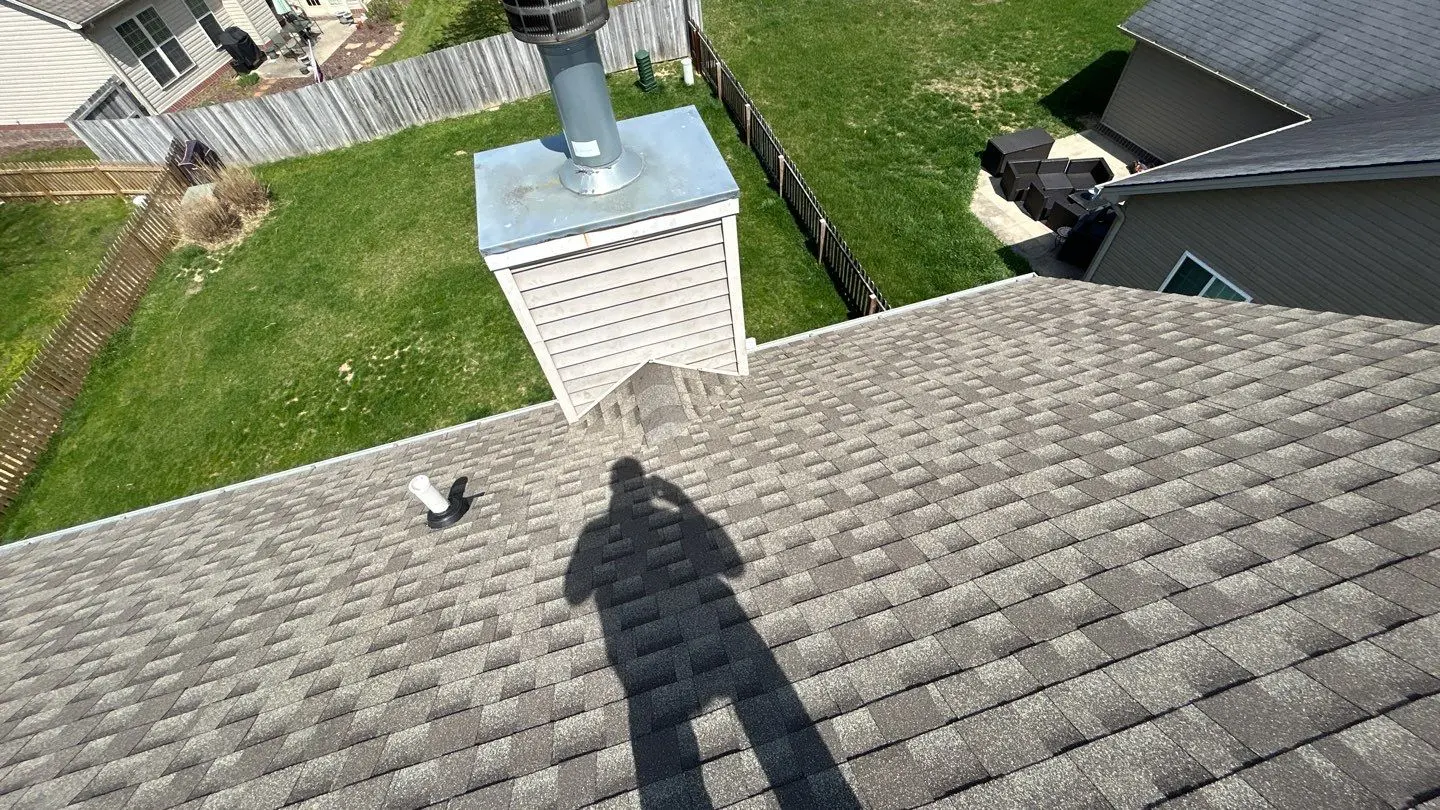 Asphalt shingle roof with chimney and ventilation pipe during residential roof inspection in Lexington KY