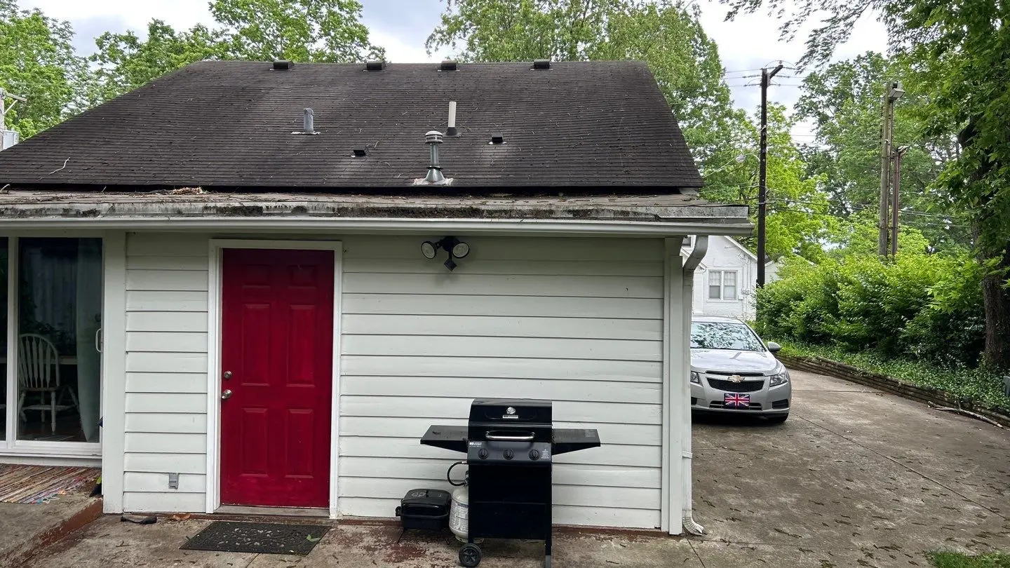 rusted residential gutter system with debris buildup