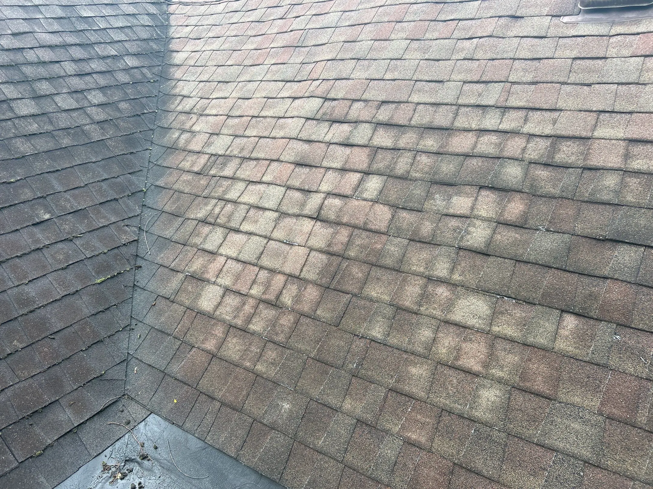 Aged and discolored asphalt shingles on residential roof in Lexington KY showing wear and granule loss