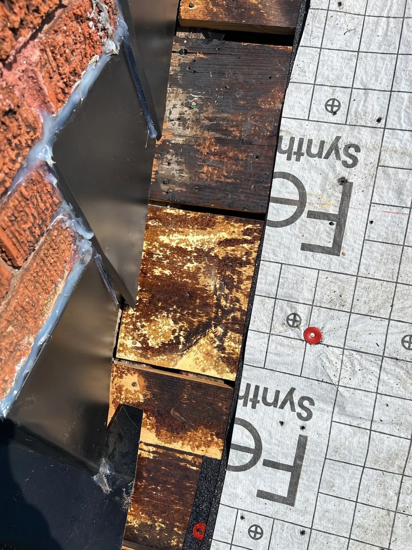 Missing roof shingles with exposed decking near wall in Lexington KY home