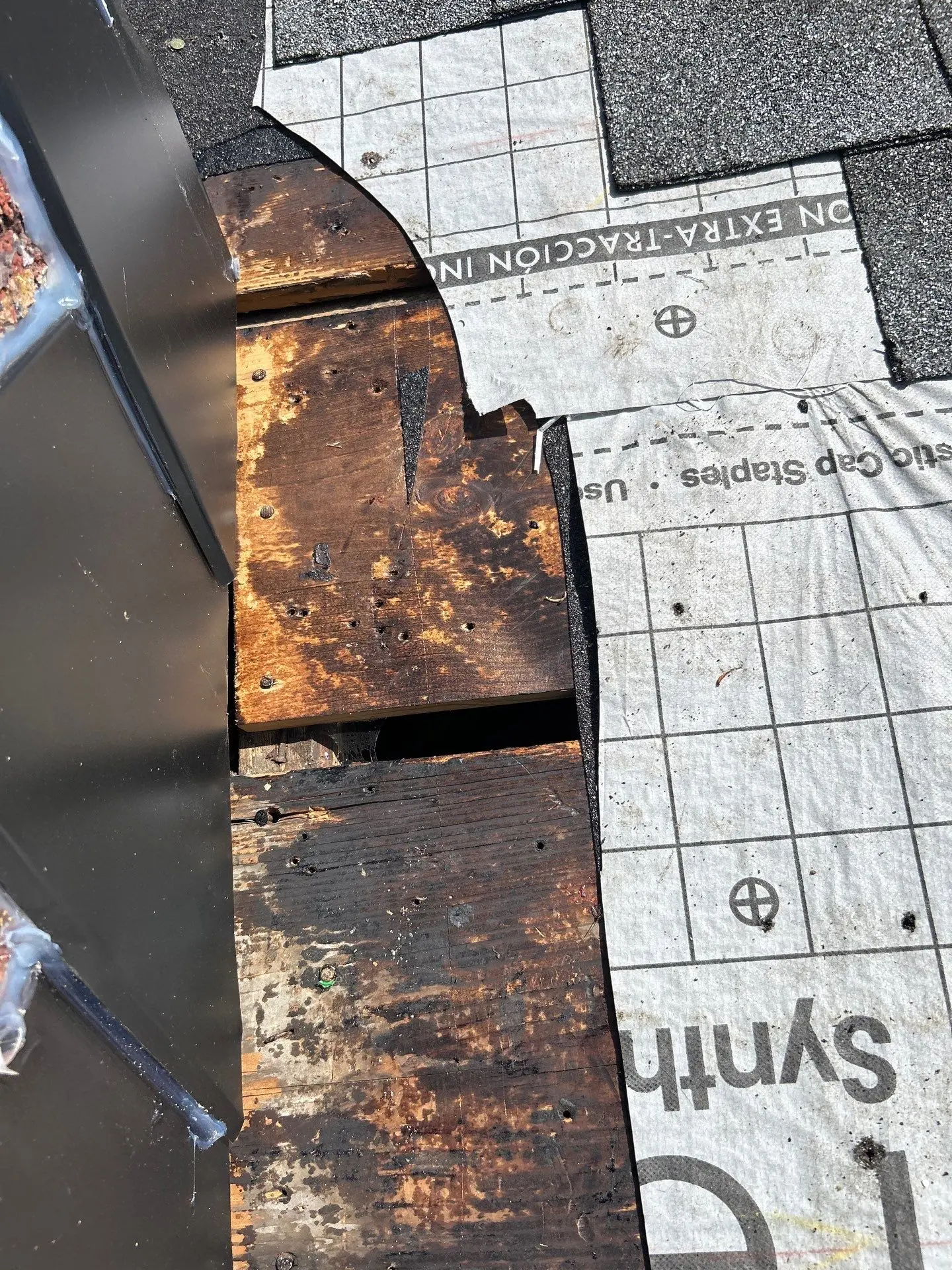 Missing shingles and rotted roof decking near chimney in Lexington KY showing water damage