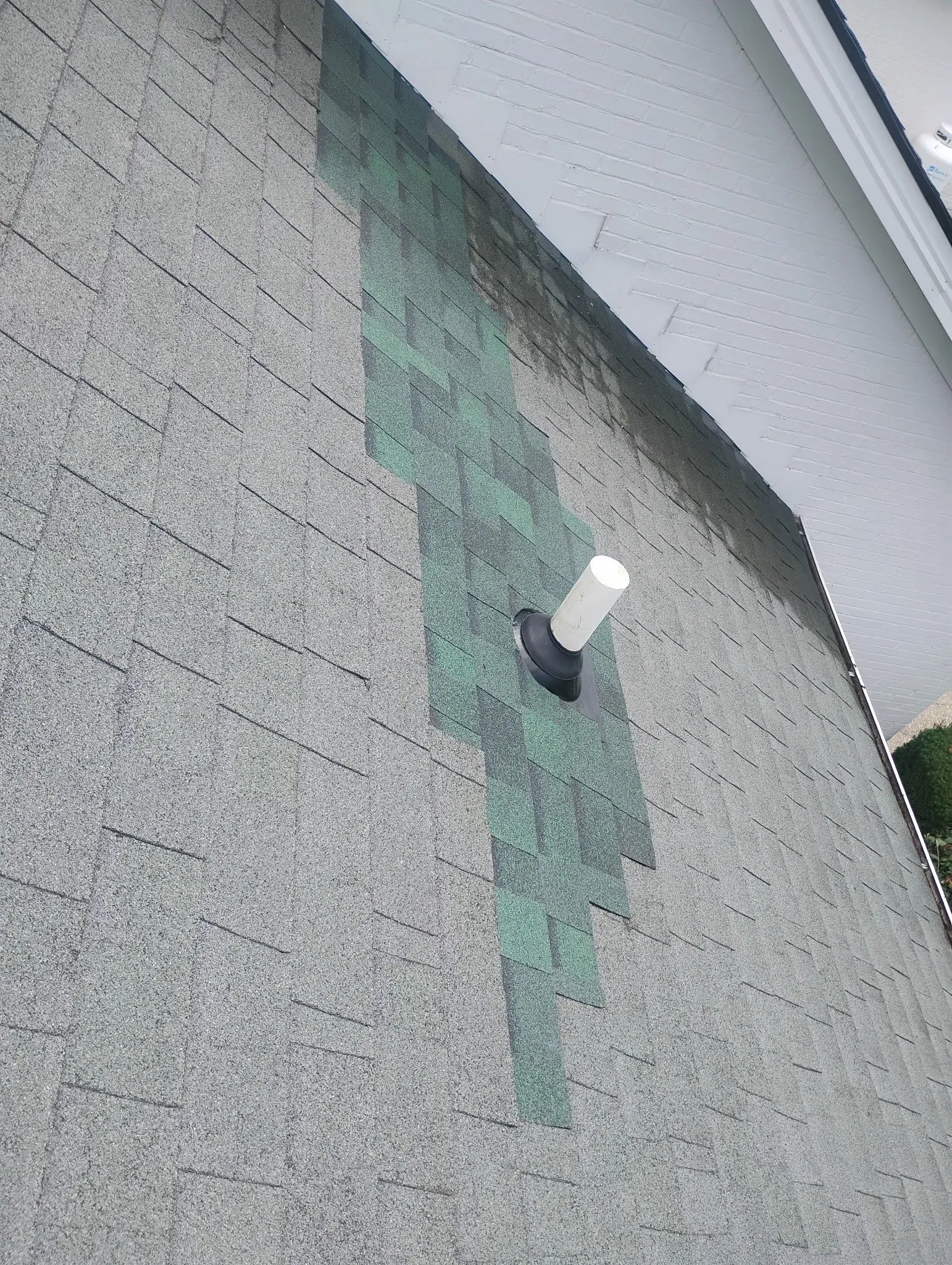 Roof vent pipe flashing repair with new shingles and water staining on roof in Lexington KY