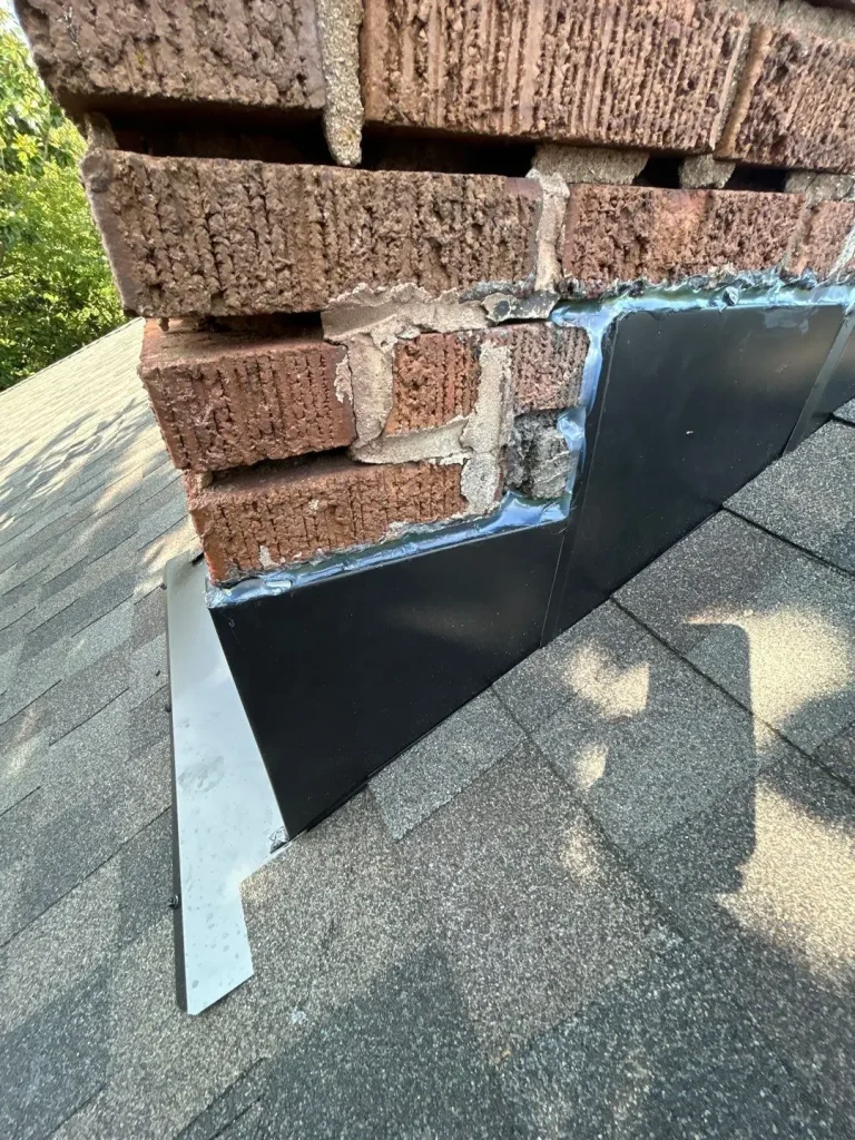 Close-up of chimney flashing and sealant on asphalt shingle roof in Richmond KY