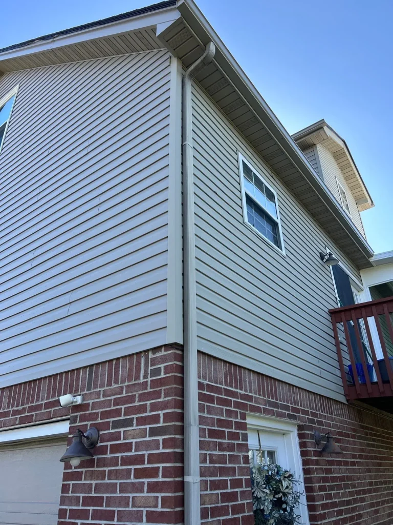 Seamless gutter and downspout system installed on Richmond KY home exterior with proper water drainage
