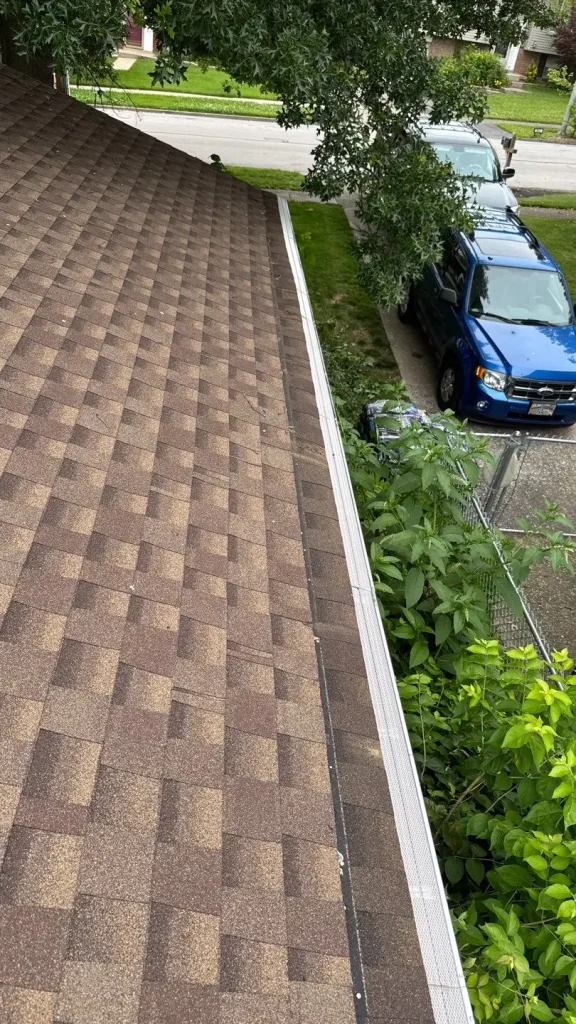 Gutter guards installed along roof edge of residential home in Richmond KY with nearby trees and debris protection