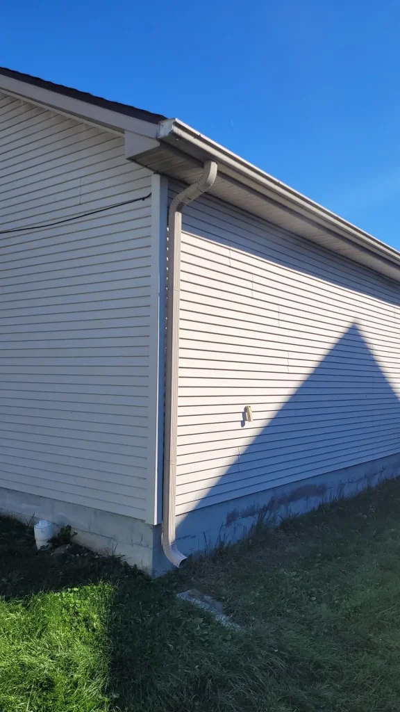 Seamless gutter system with downspout on Lexington KY home exterior for proper drainage