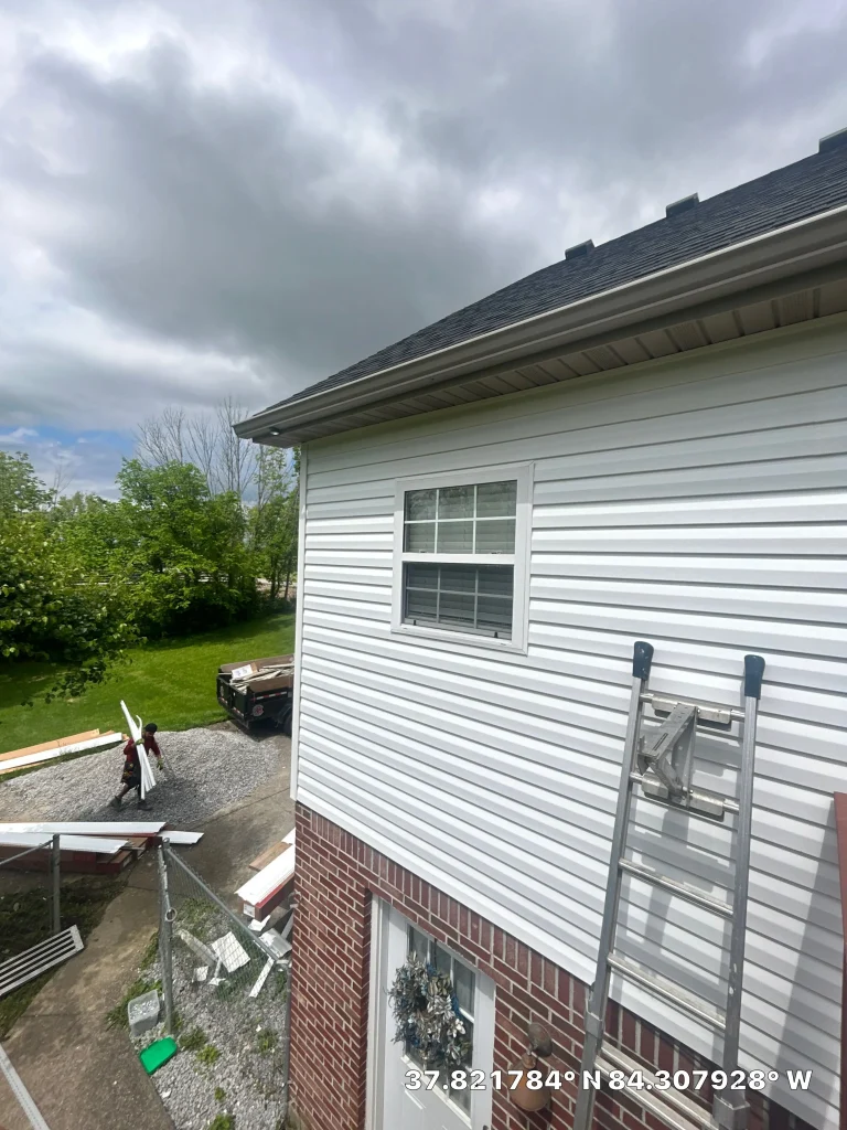 Vinyl siding installation on home exterior with ladder in Berea KY