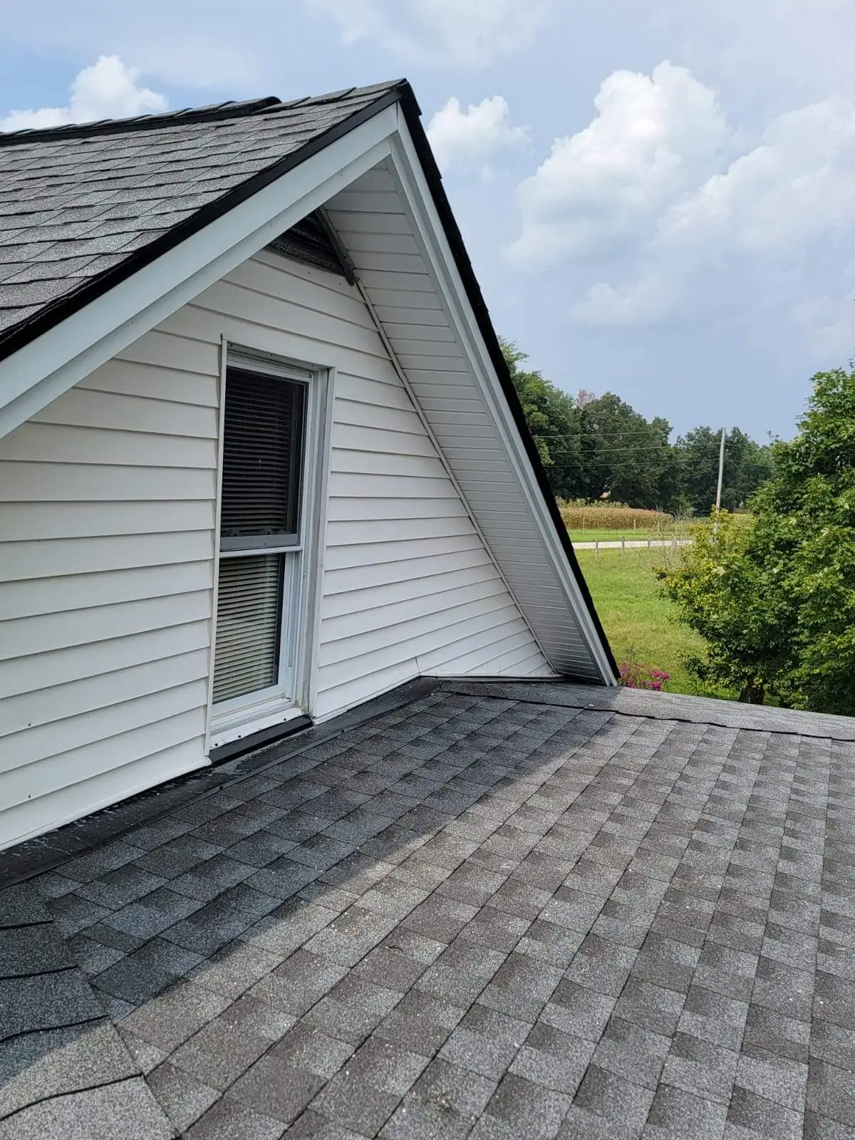 White-sided dormer and gray shingle roofline on a home in Irvine, KY