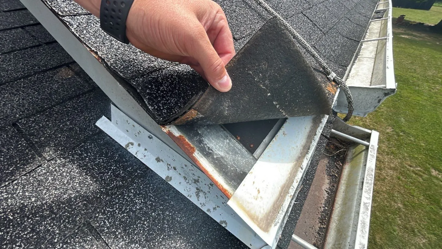 Hand lifting rusted, damaged roof valley flashing on a home in Irvine, KY