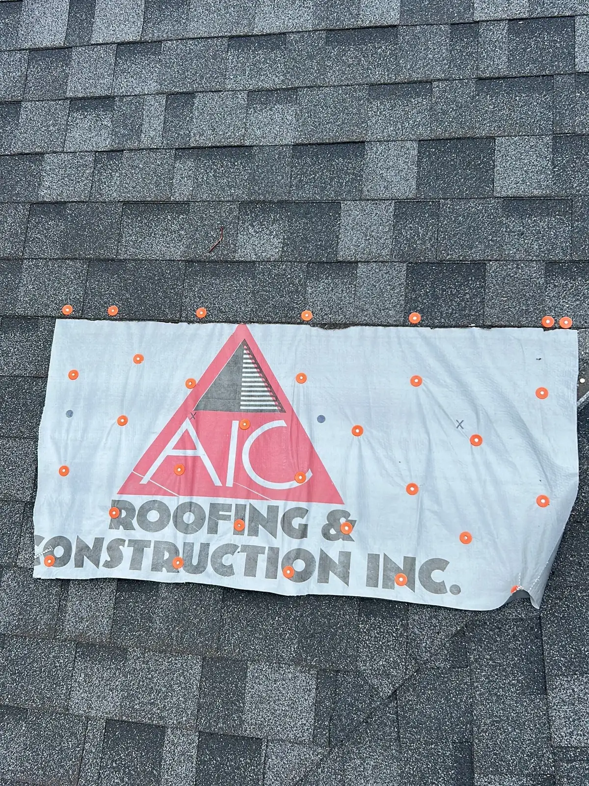 AIC Roofing and Construction banner on a shingle roof during a Louisville, KY multi-family project