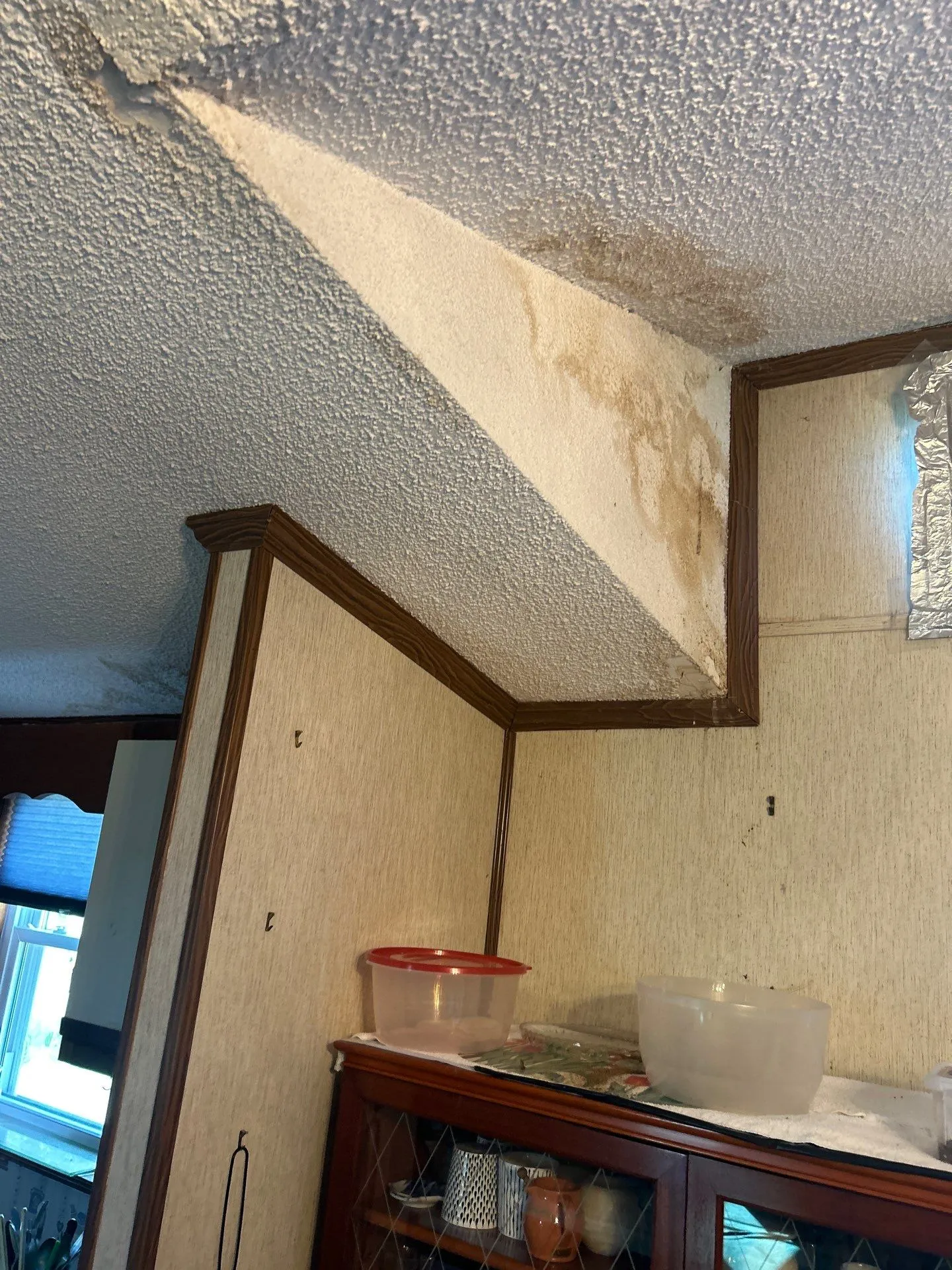 Water-stained, peeling ceiling in a corner from a roof leak in Lancaster, KY