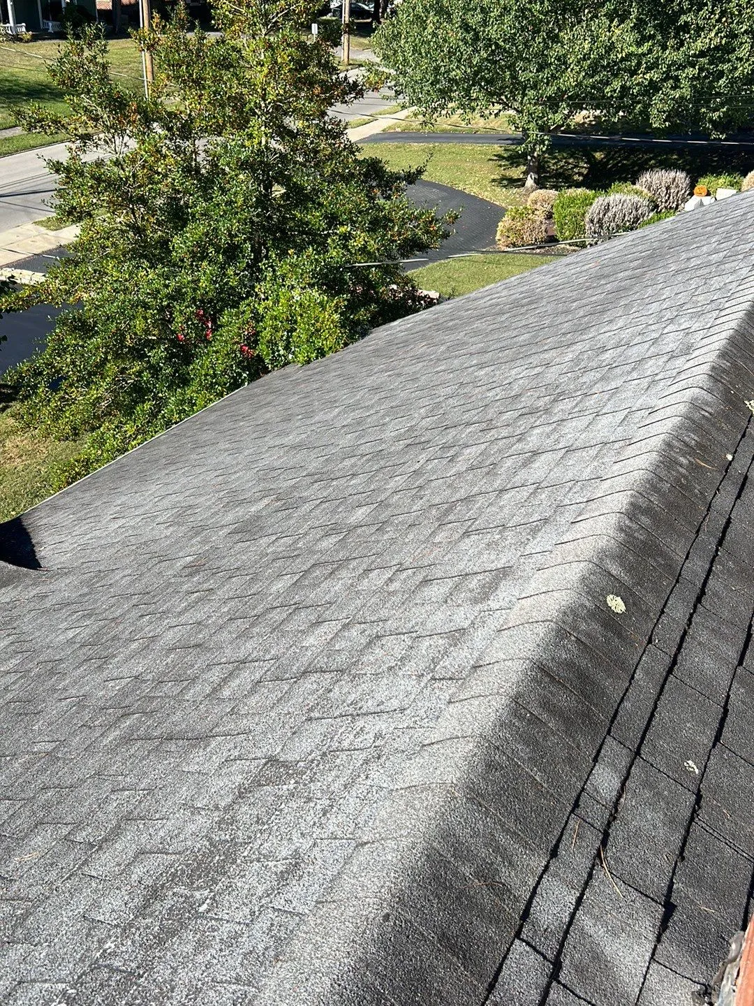 Worn gray shingle roof slope with granule loss above a street in Lancaster, KY