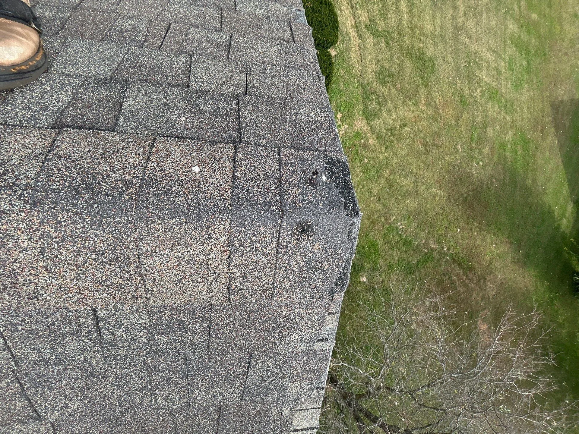Worn shingle roof edge with granule loss and a damaged spot in Mt. Sterling, KY