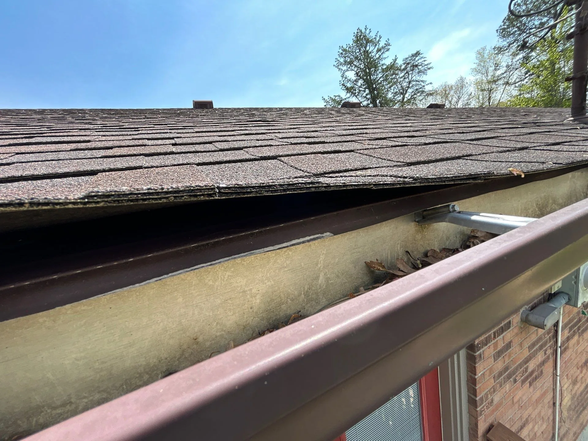 Leaves and debris in a gutter gapping away from the roof on an Irvine, KY home.
