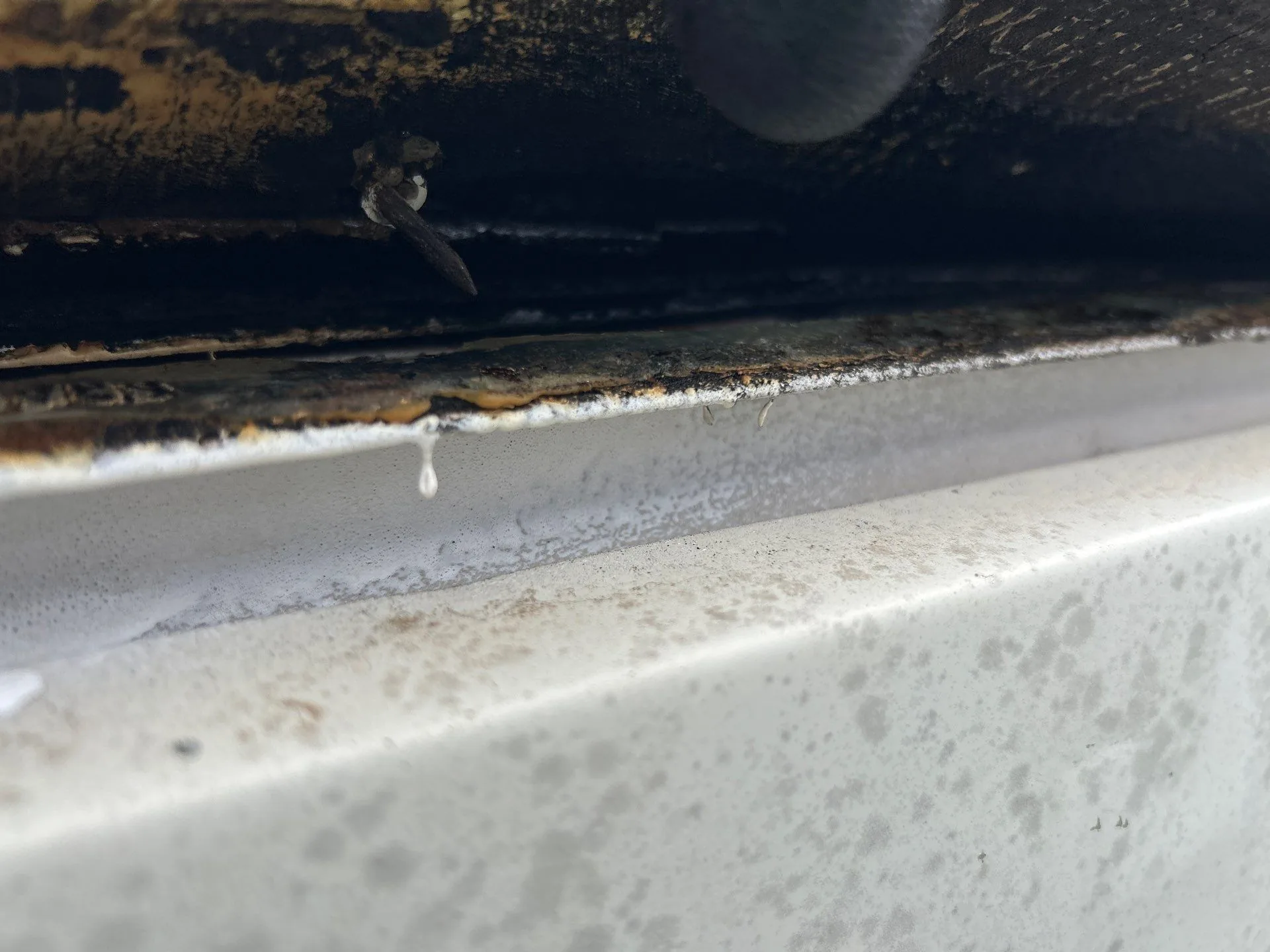 Close-up of a rusted old gutter with a loose nail needing replacement on an Irvine, KY home.