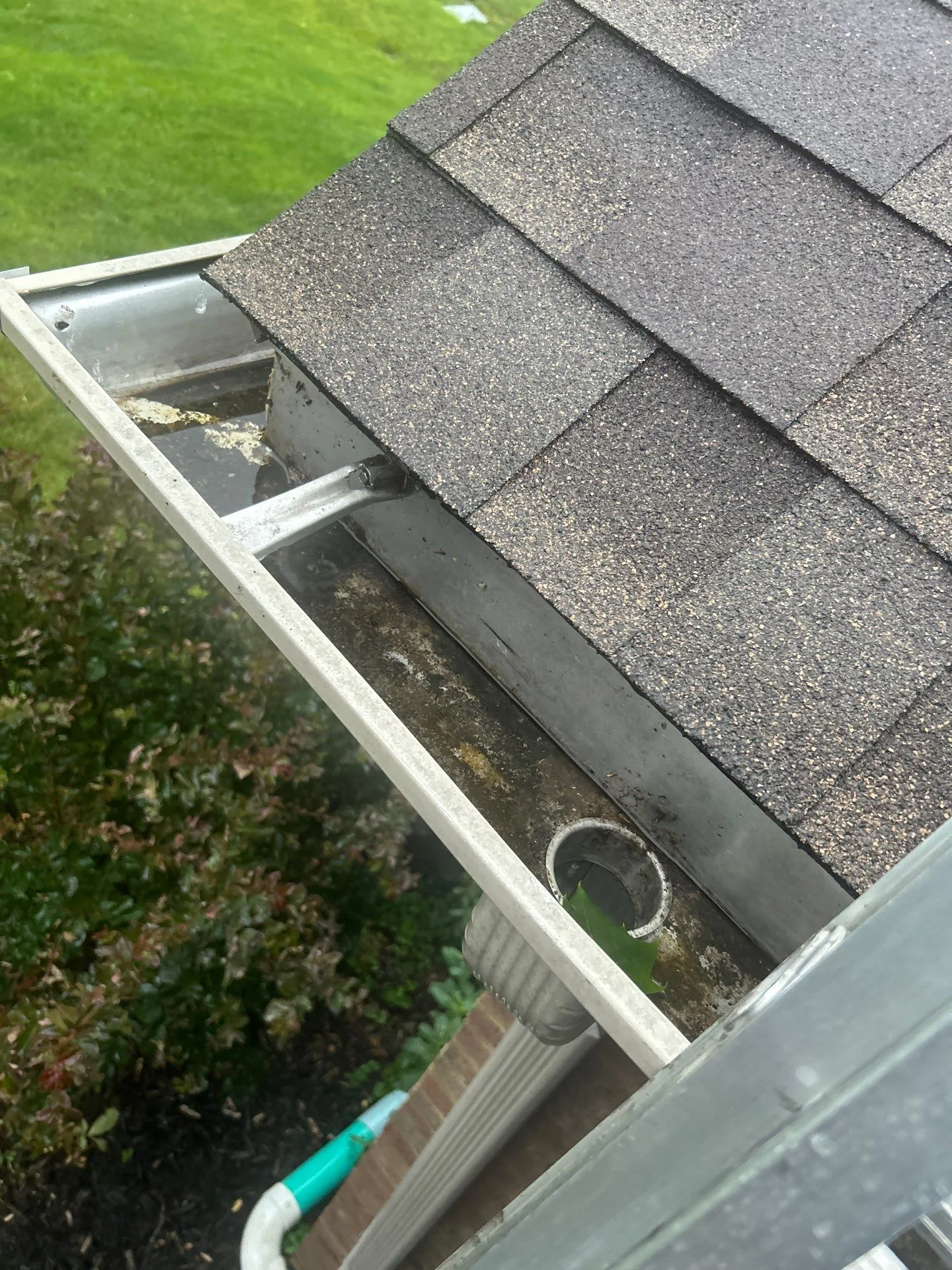 Open gutter section with debris near the downspout outlet on a Mt. Sterling, KY home.