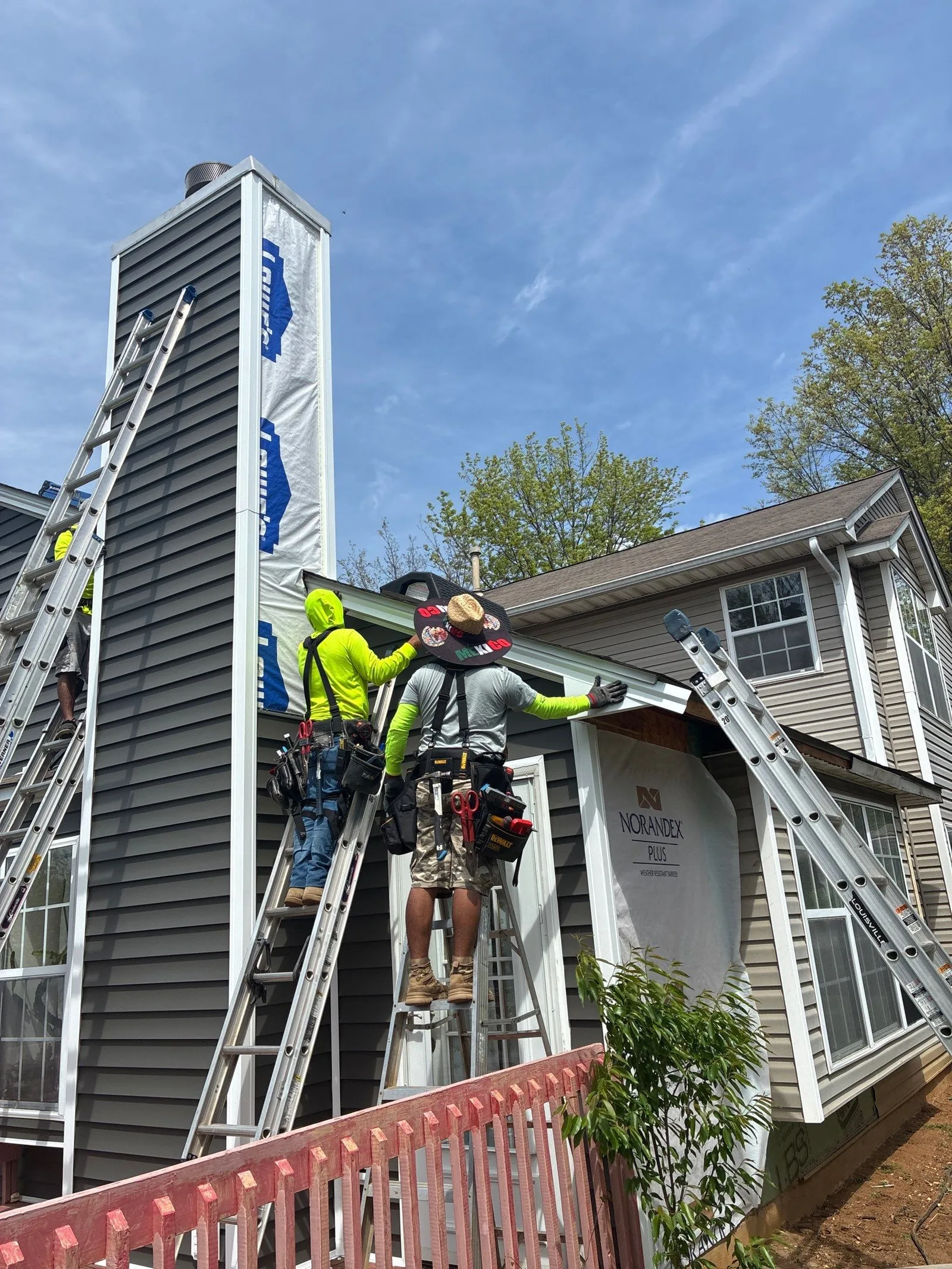 AIC Roofing and Construction crew installing new siding on a Lexington, KY home