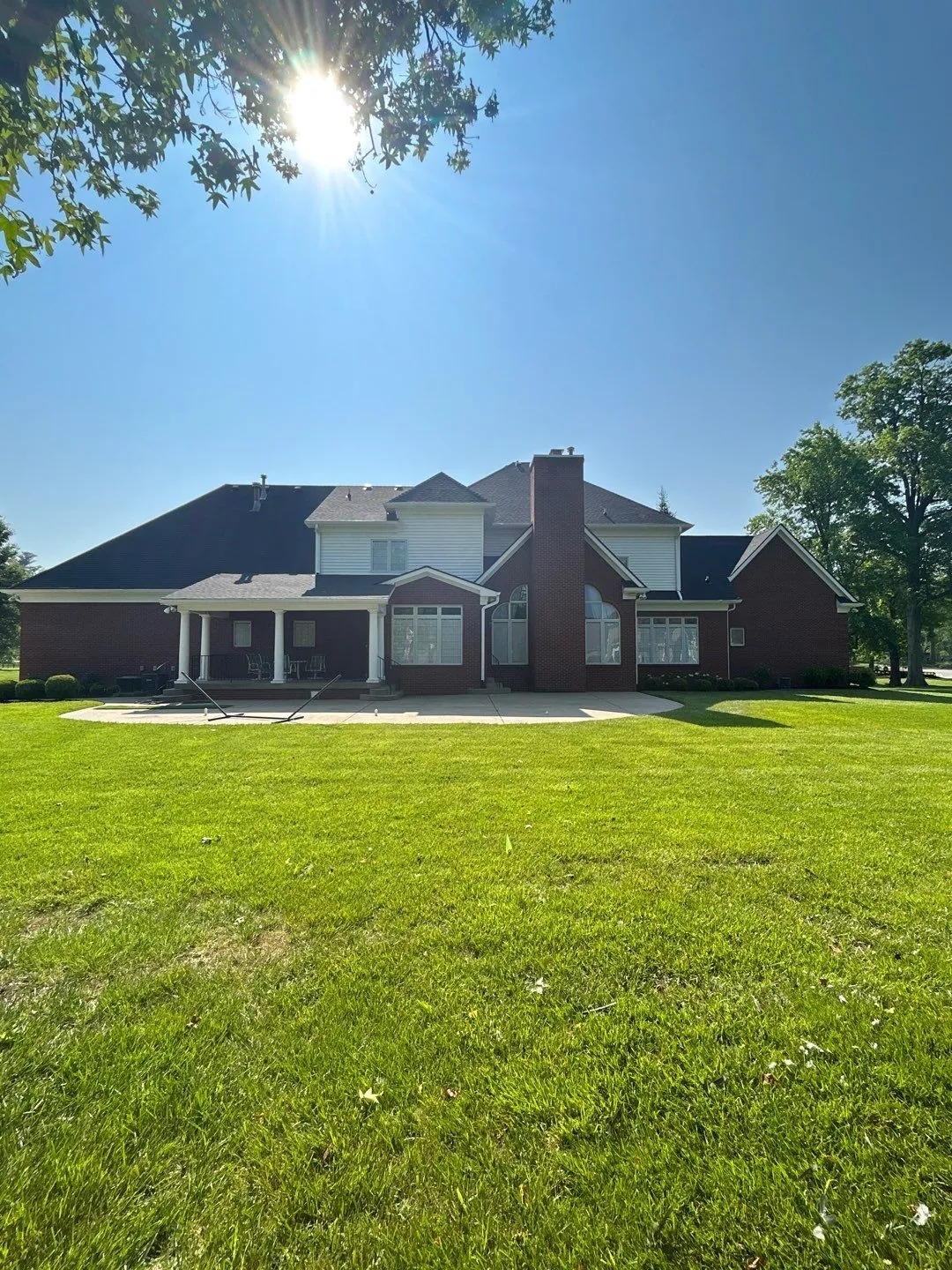 Large two-story brick home with a dark shingle roof and chimney in Lancaster, KY