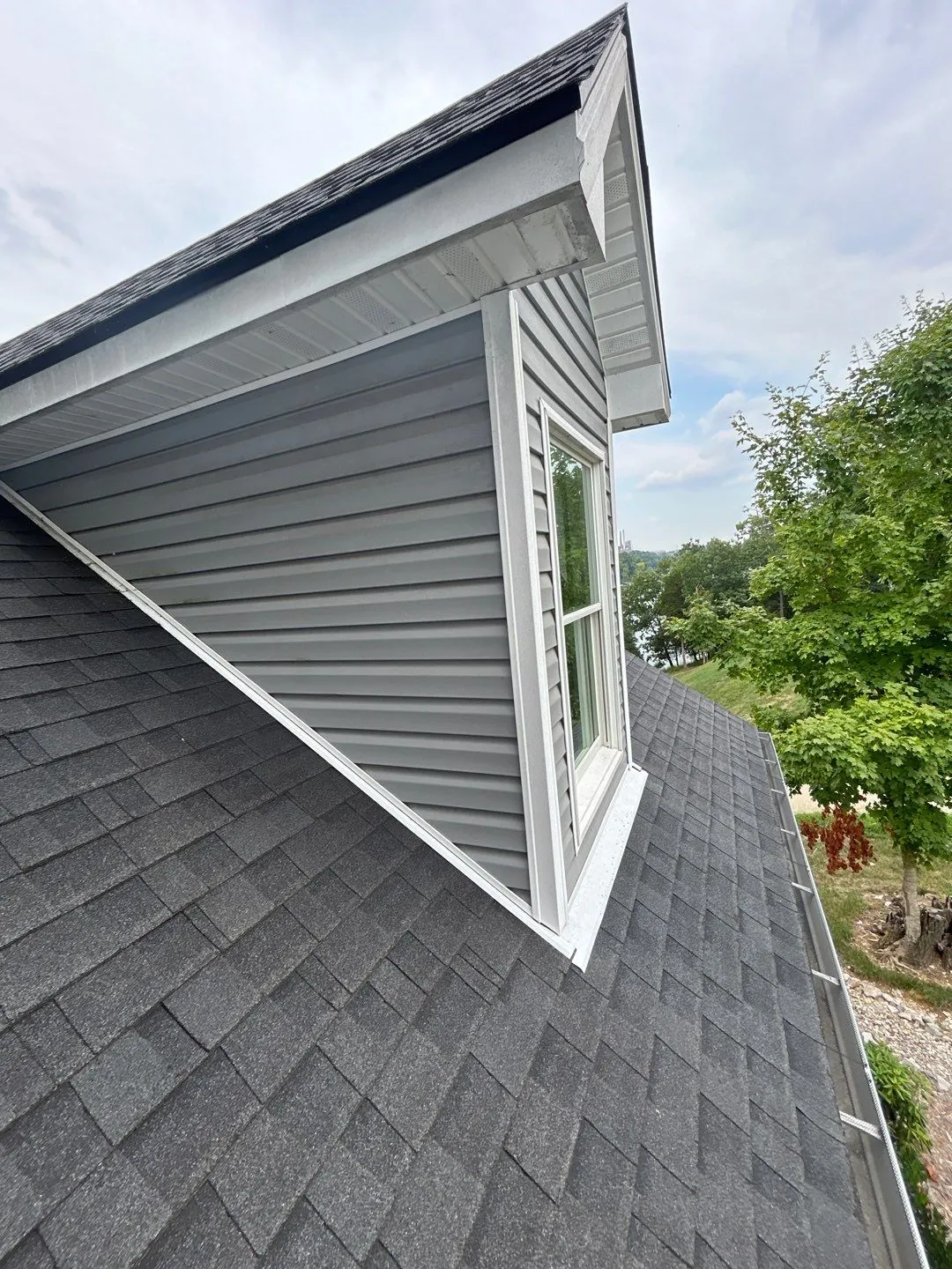 Gray-sided dormer meeting a dark shingle roof with a lake view in Lancaster, KY