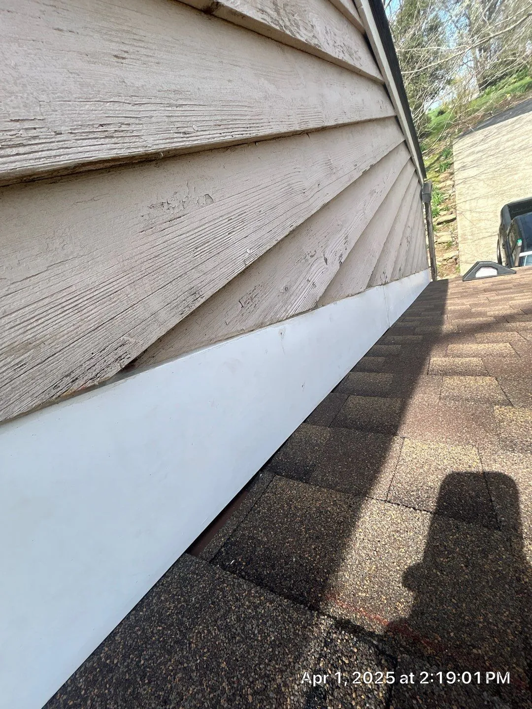 New white flashing where a brown shingle roof meets wood siding in Lancaster, KY
