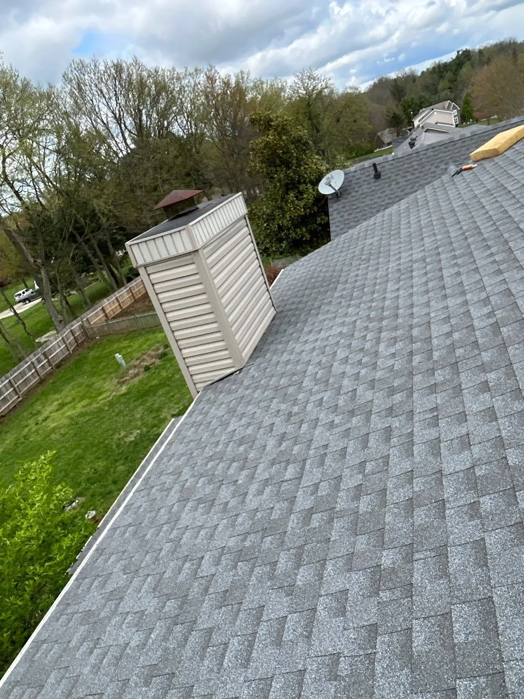 Gray shingle roof with a vinyl-sided chimney chase and satellite dish in Mt. Sterling, KY