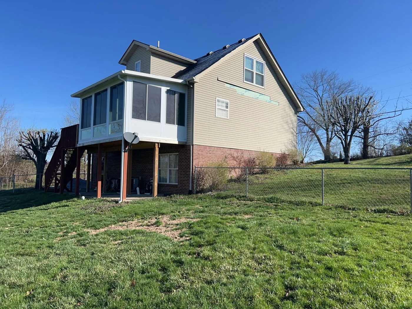 Missing siding panel and exposed sheathing from damage on a Richmond, KY home