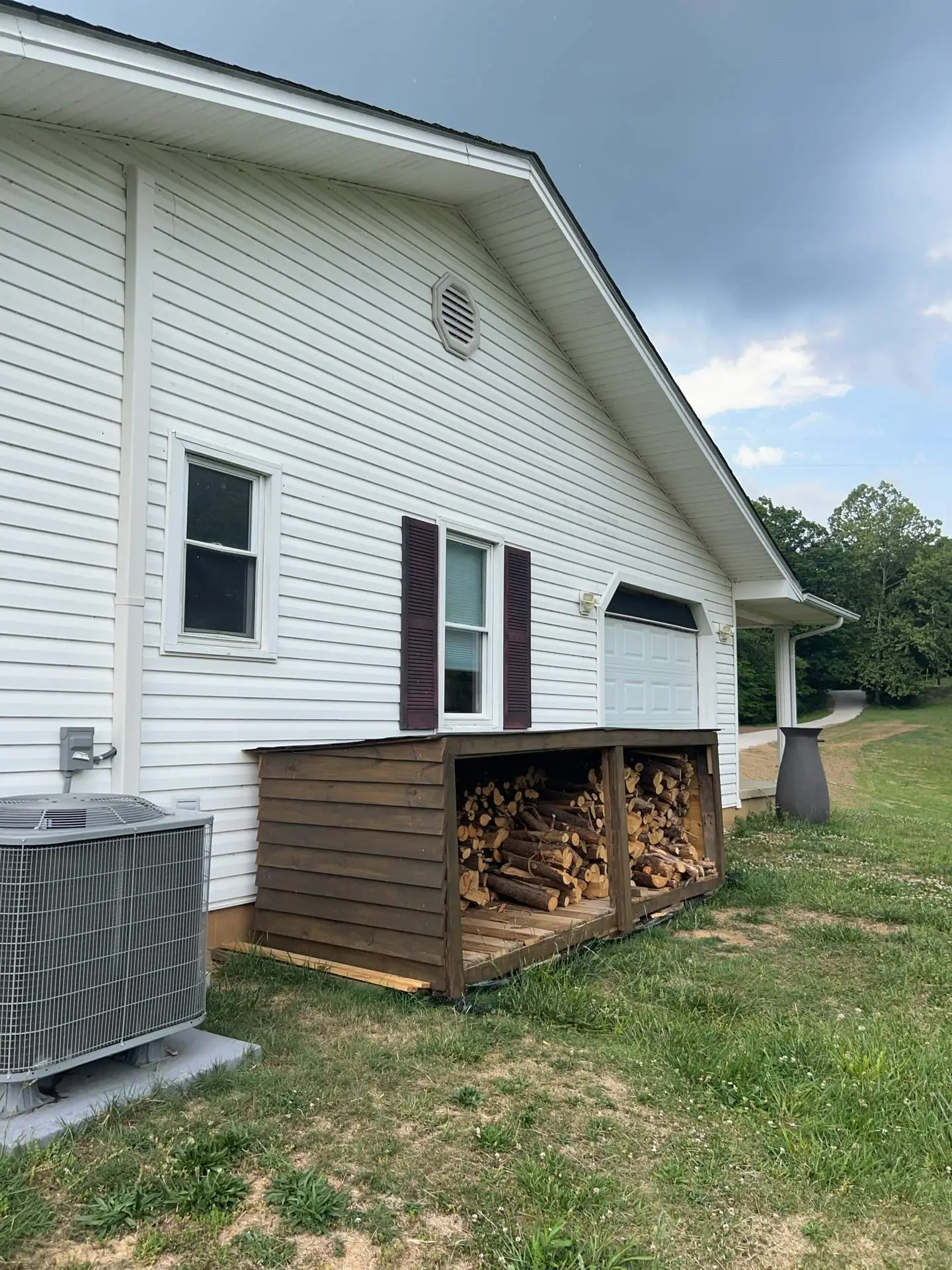 White vinyl siding on a home’s gable end with shutters and gable vent in Irvine, KY