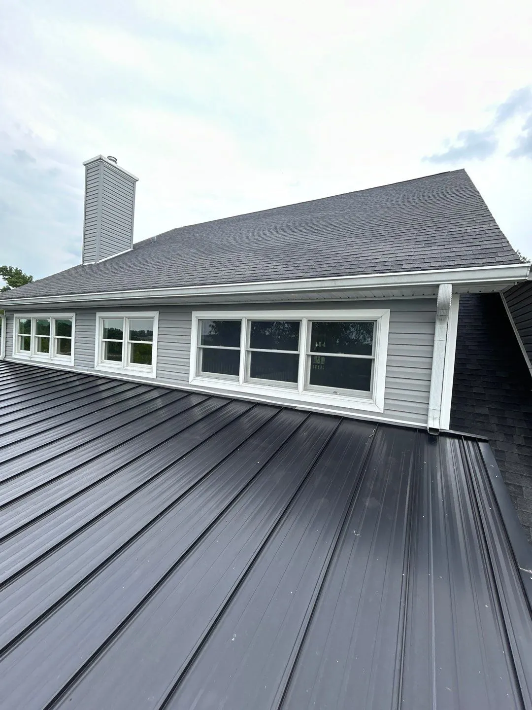 Gray vinyl siding with white-trimmed windows above a metal roof in Mt. Sterling, KY