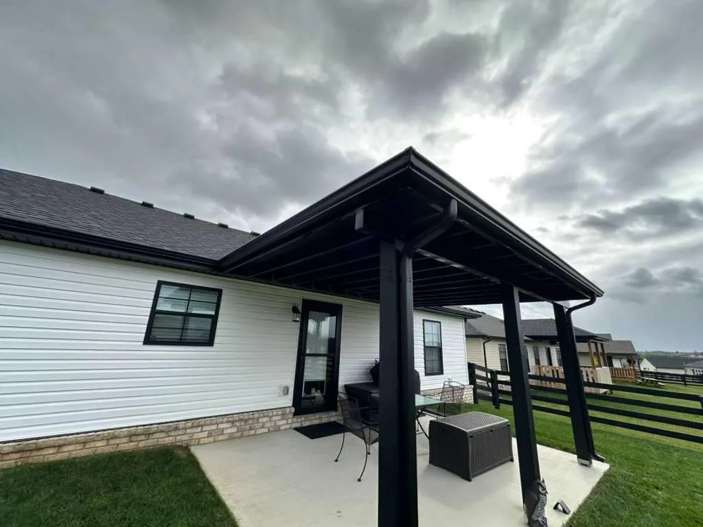 New black gutters on a white home with a covered patio in Waco, KY.